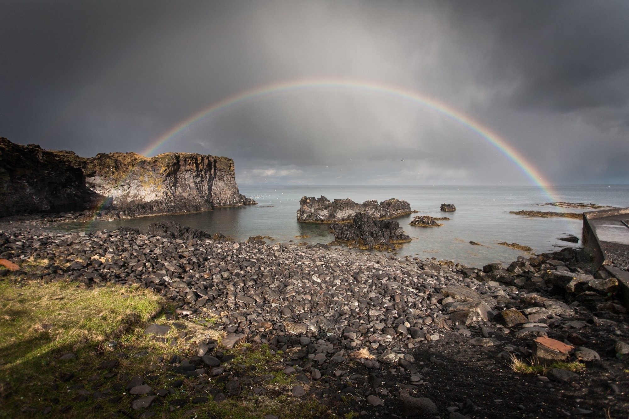 Arc‑en‑ciel éclatant sur les rochers et l’eau