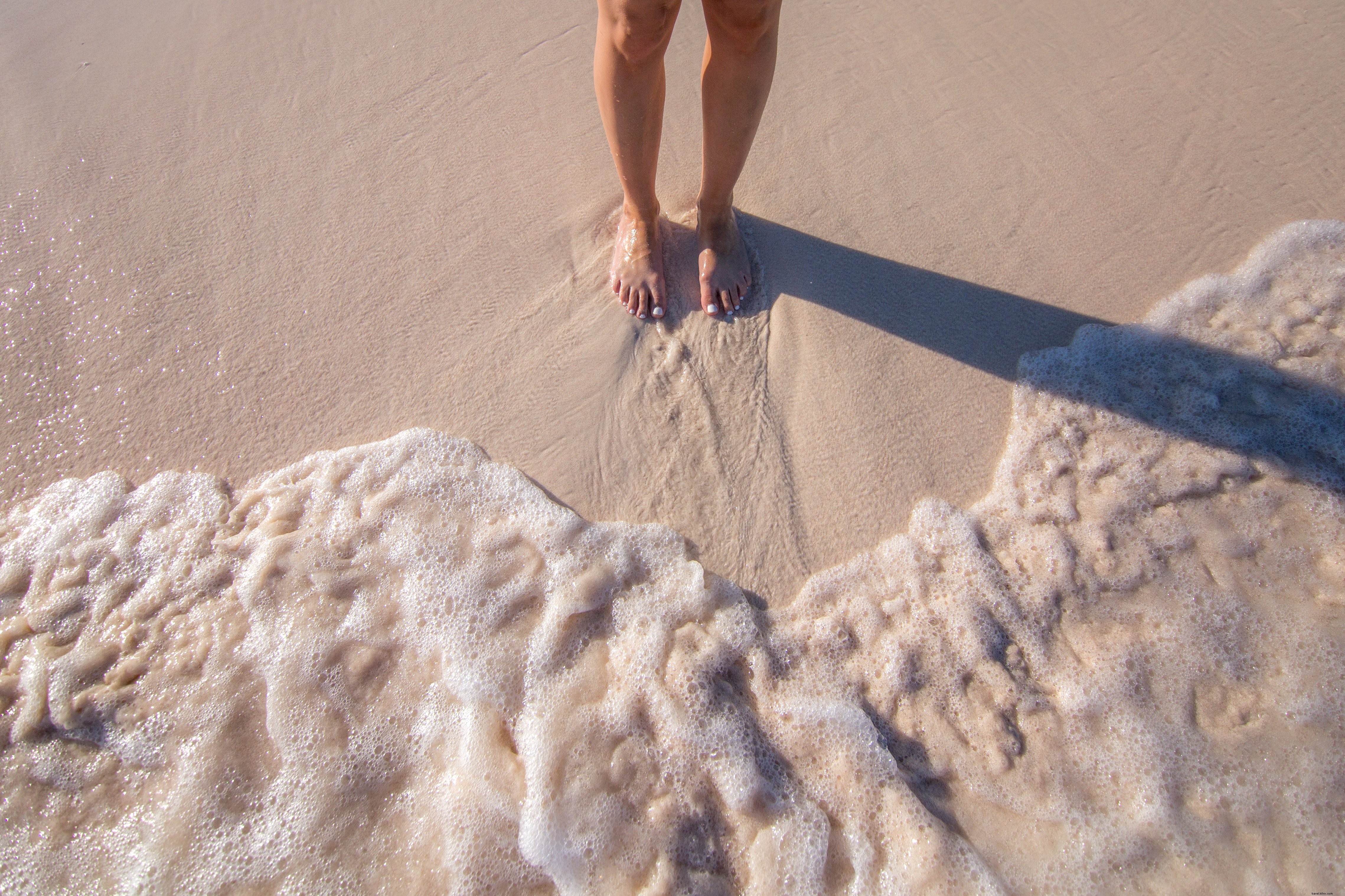 Photo : pieds de femme dans le sable et les vagues