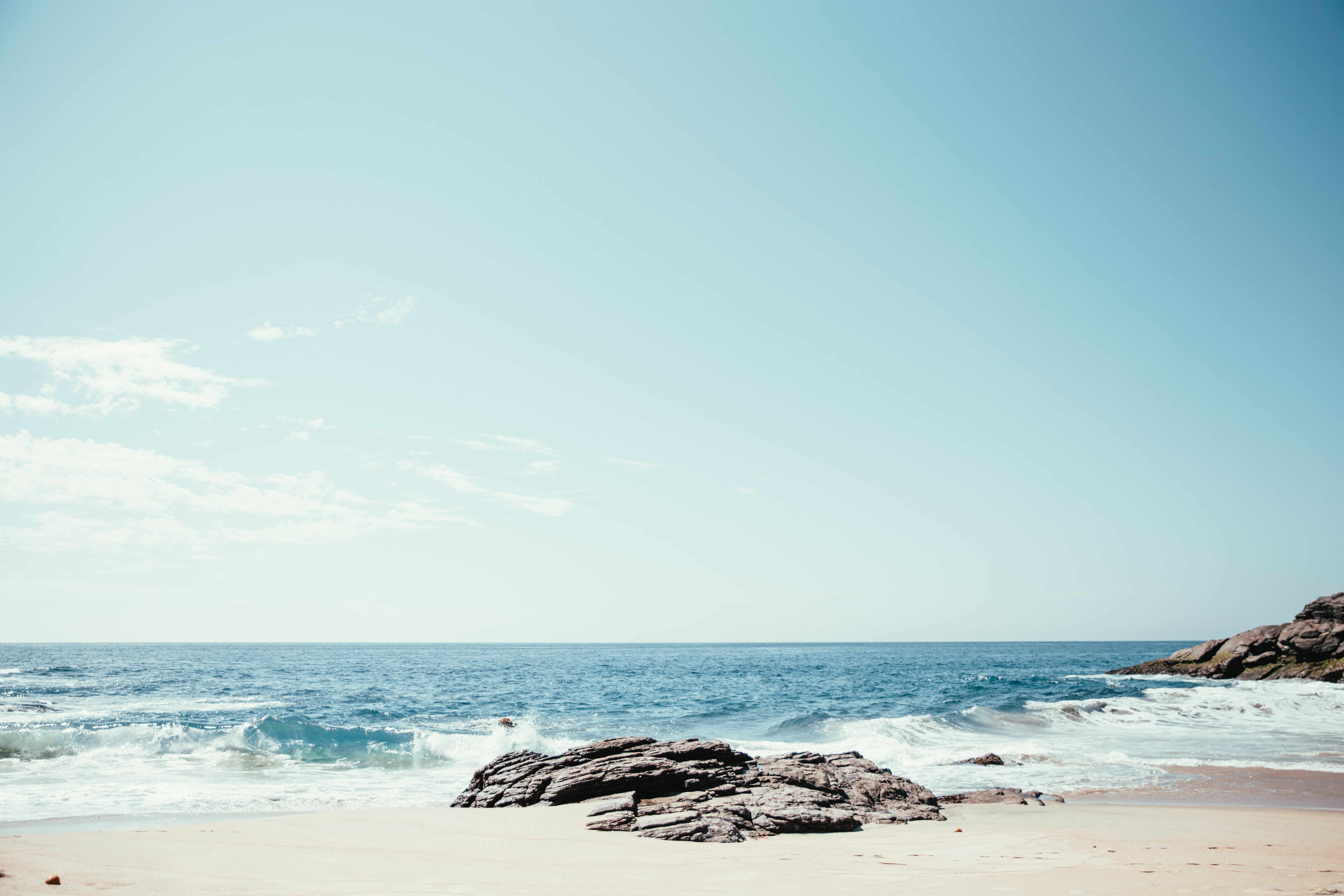 Vagues déferlantes sur rochers et sable – Photo