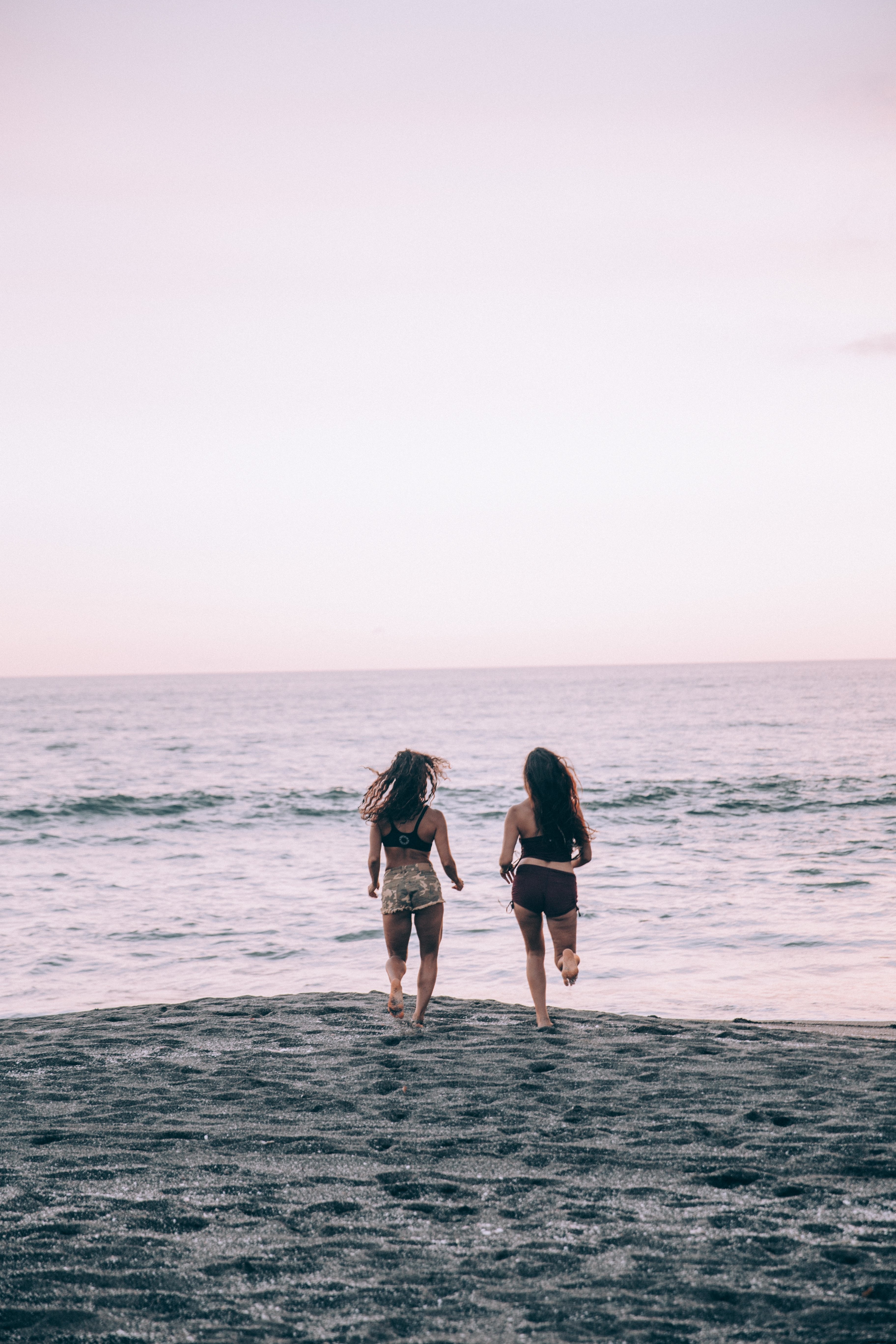 Deux femmes courant sur la plage au coucher du soleil