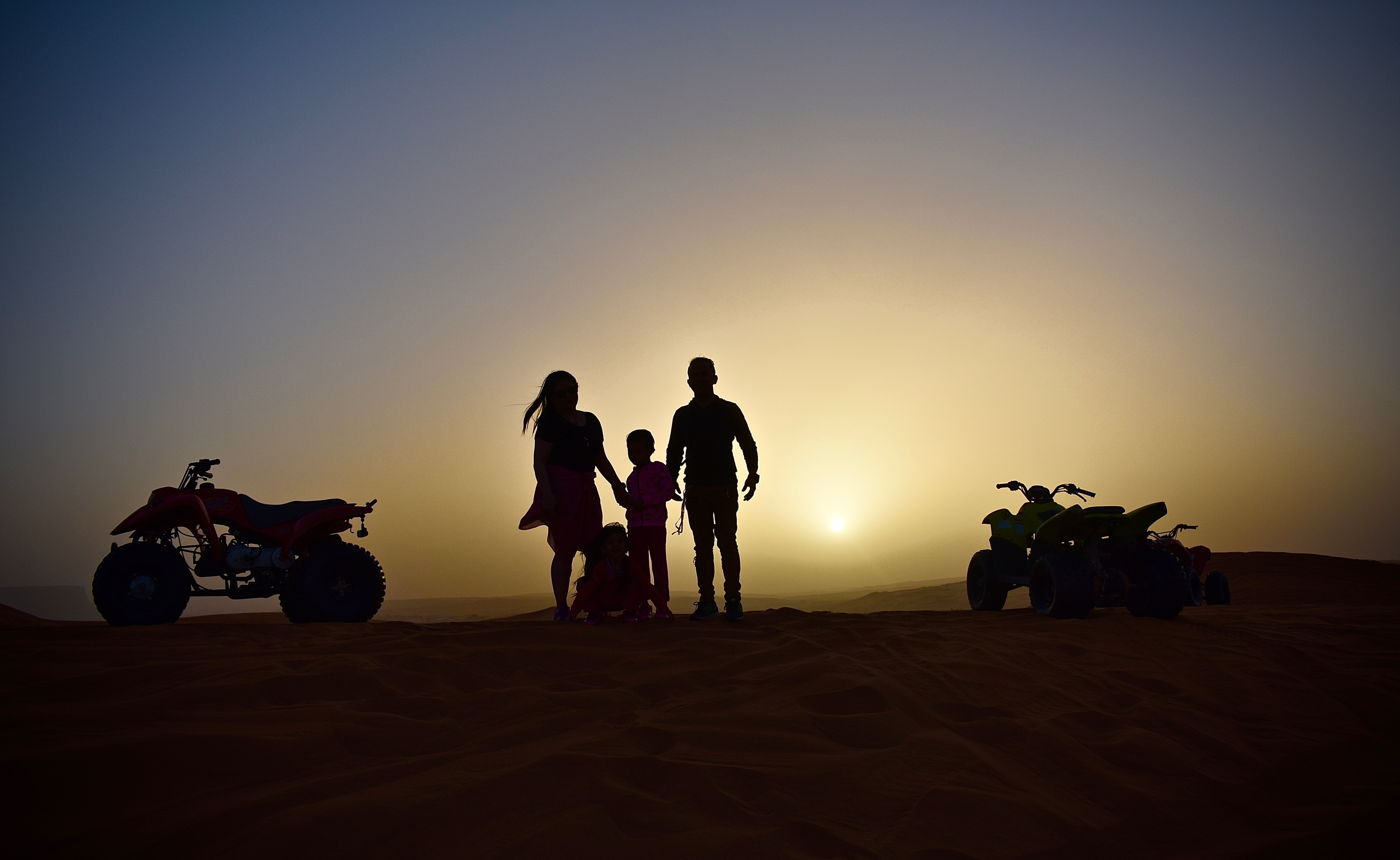 Famille en balade en quad au coucher du soleil