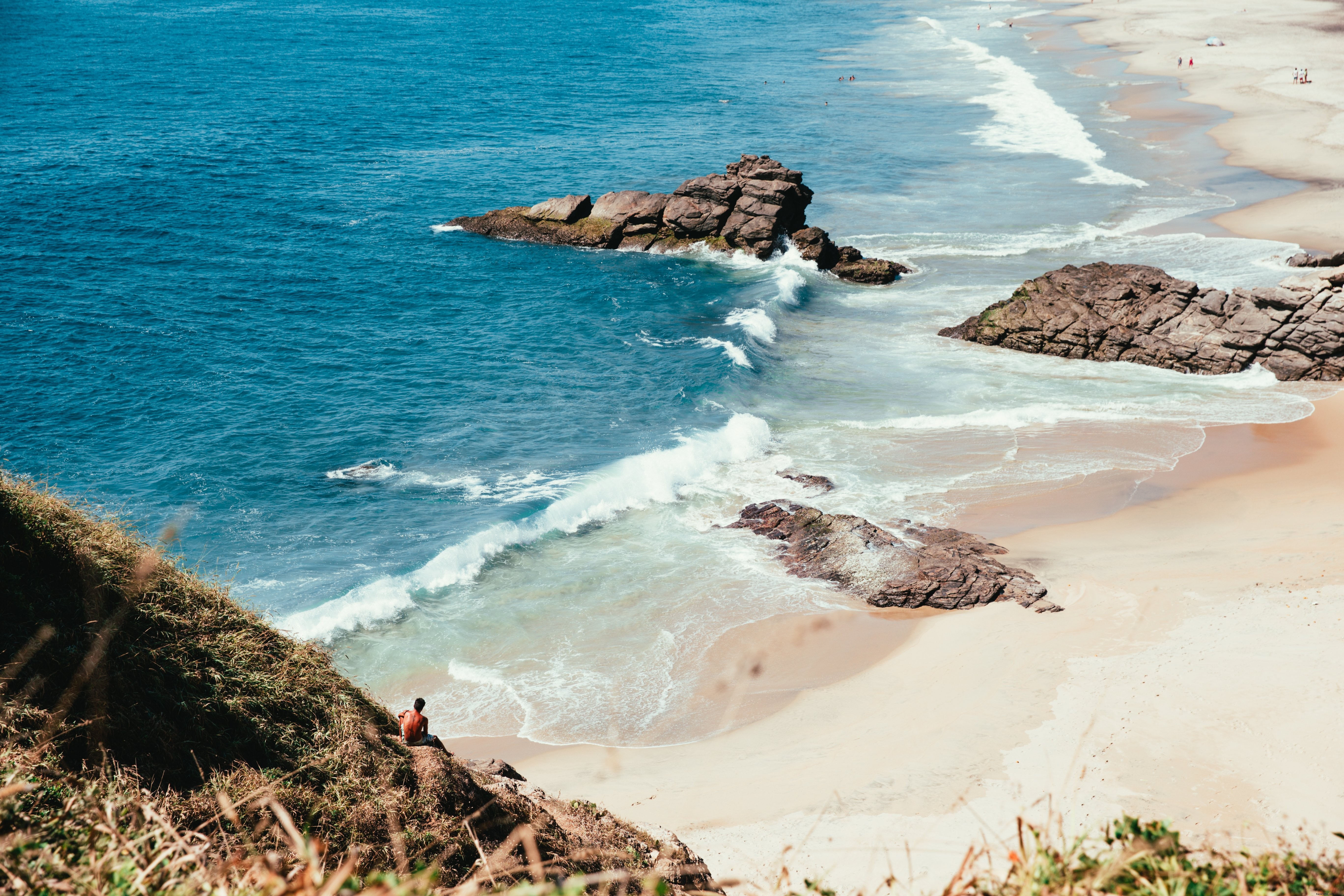 Photo : Vagues de l océan se brisant sur les rochers et le sable