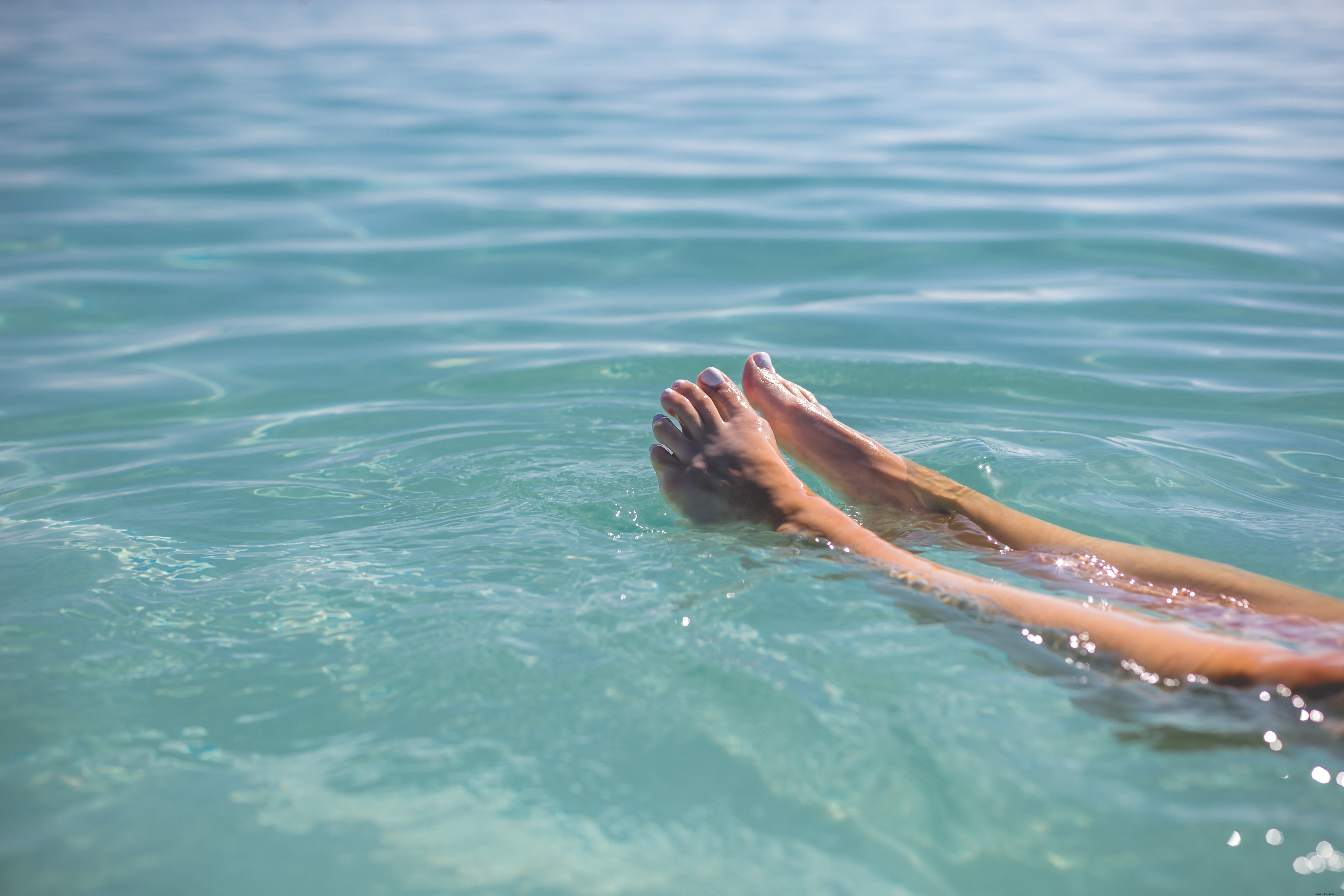 Photo de pieds flottant dans l eau bleue