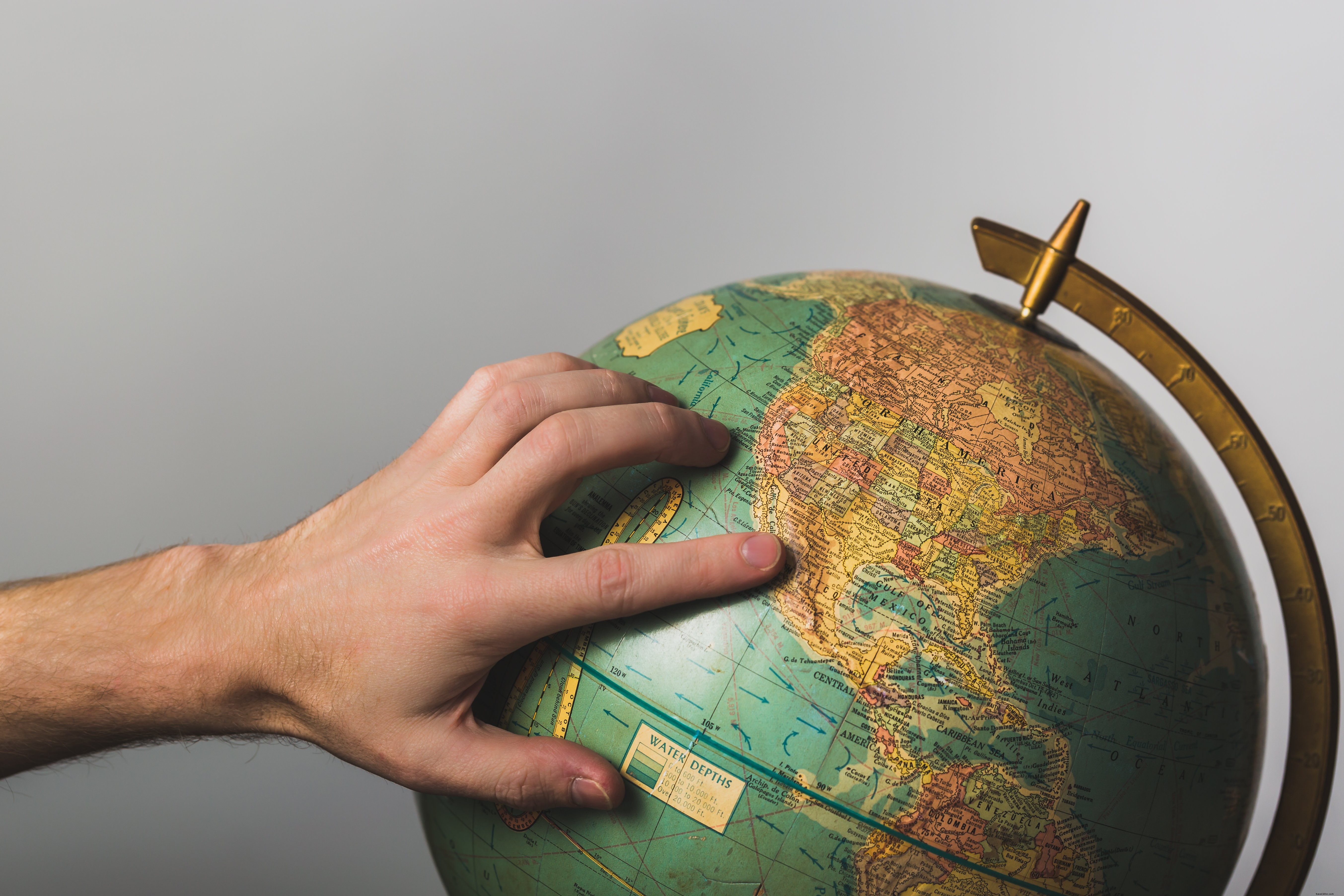 Main posée sur la photo du globe