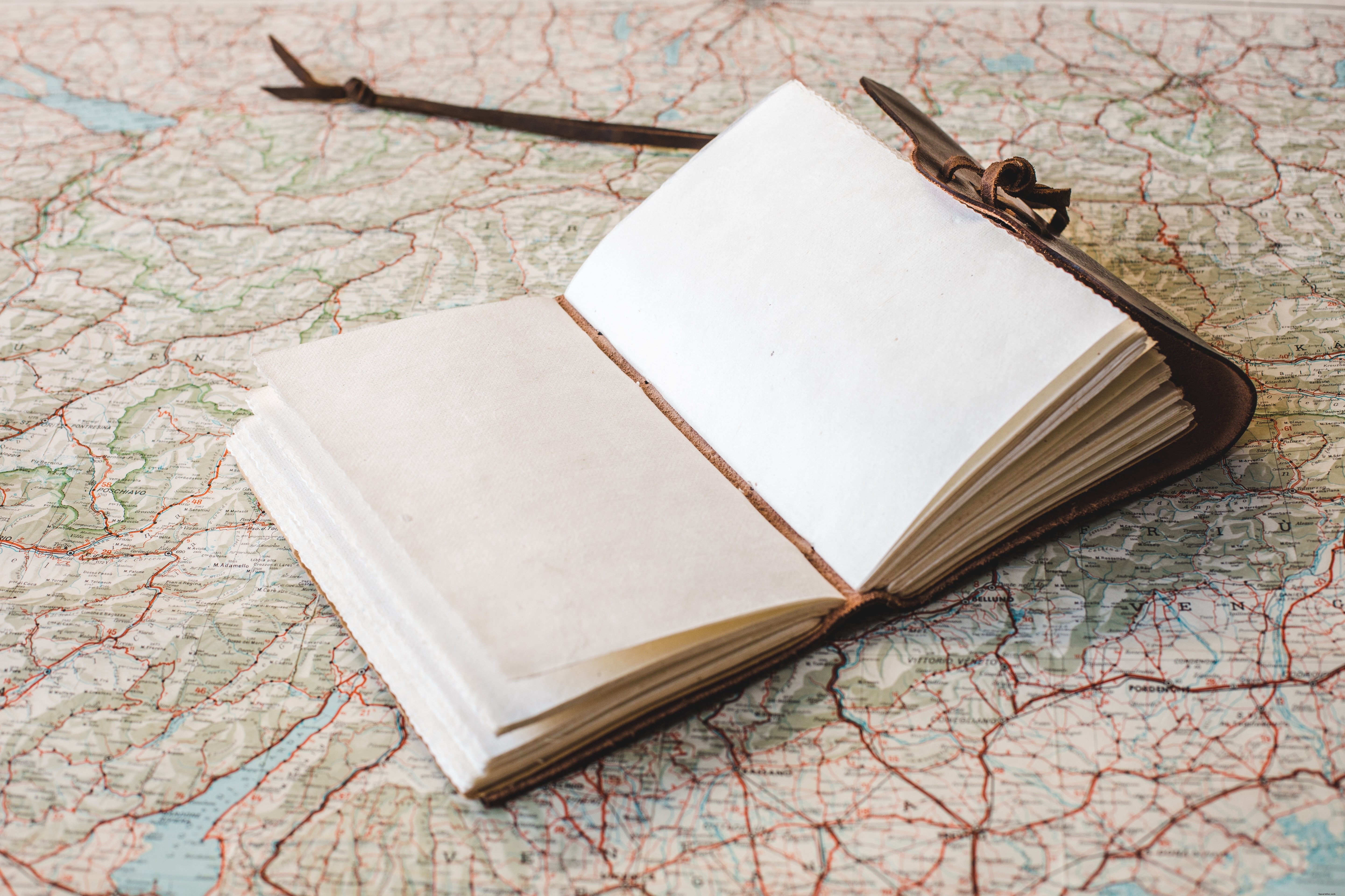 Photo : cahier ouvert posé sur une carte du monde
