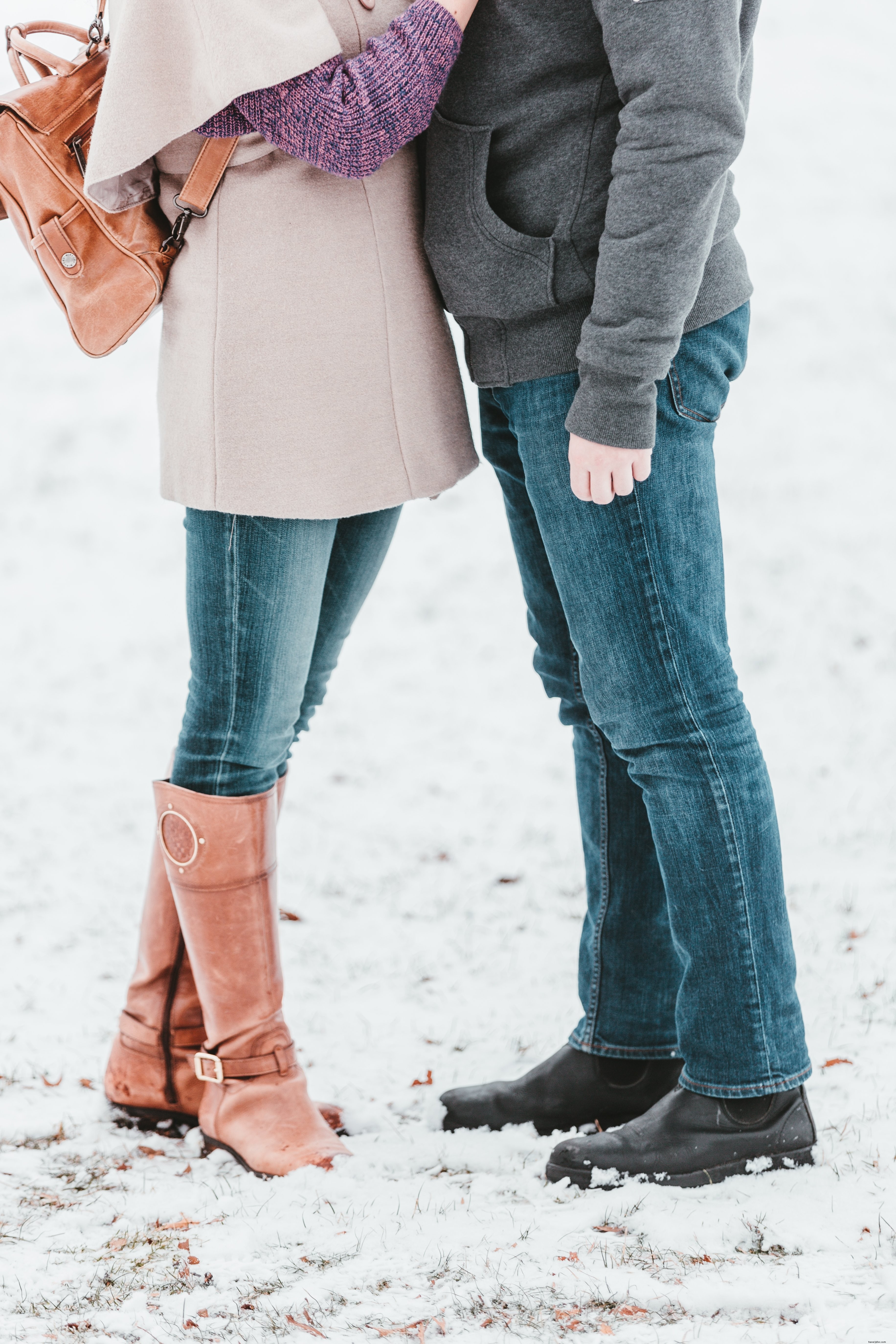 Un couple partage une étreinte chaleureuse sous la neige