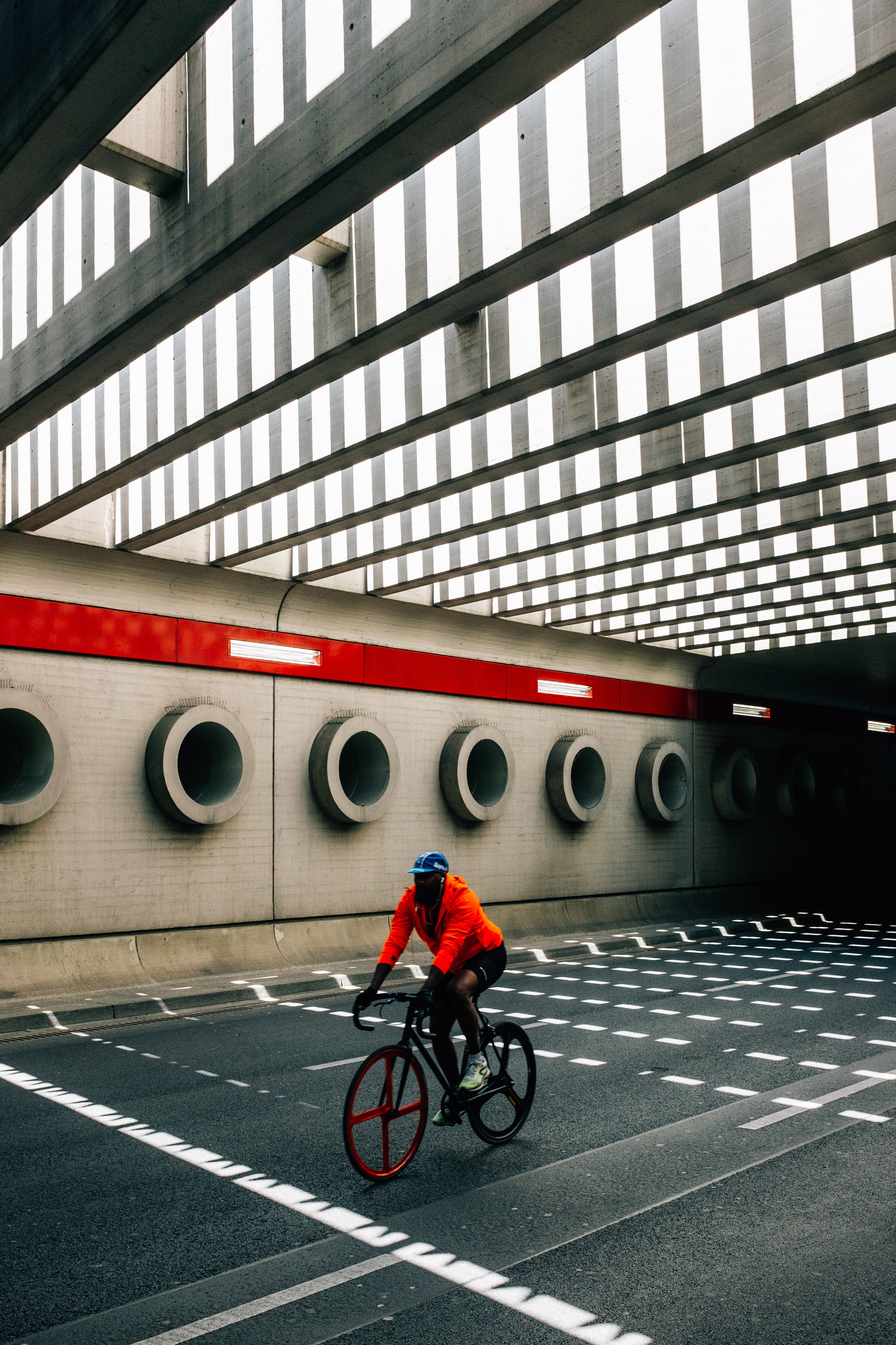 Photo : Une personne en orange fait du vélo sous un pont