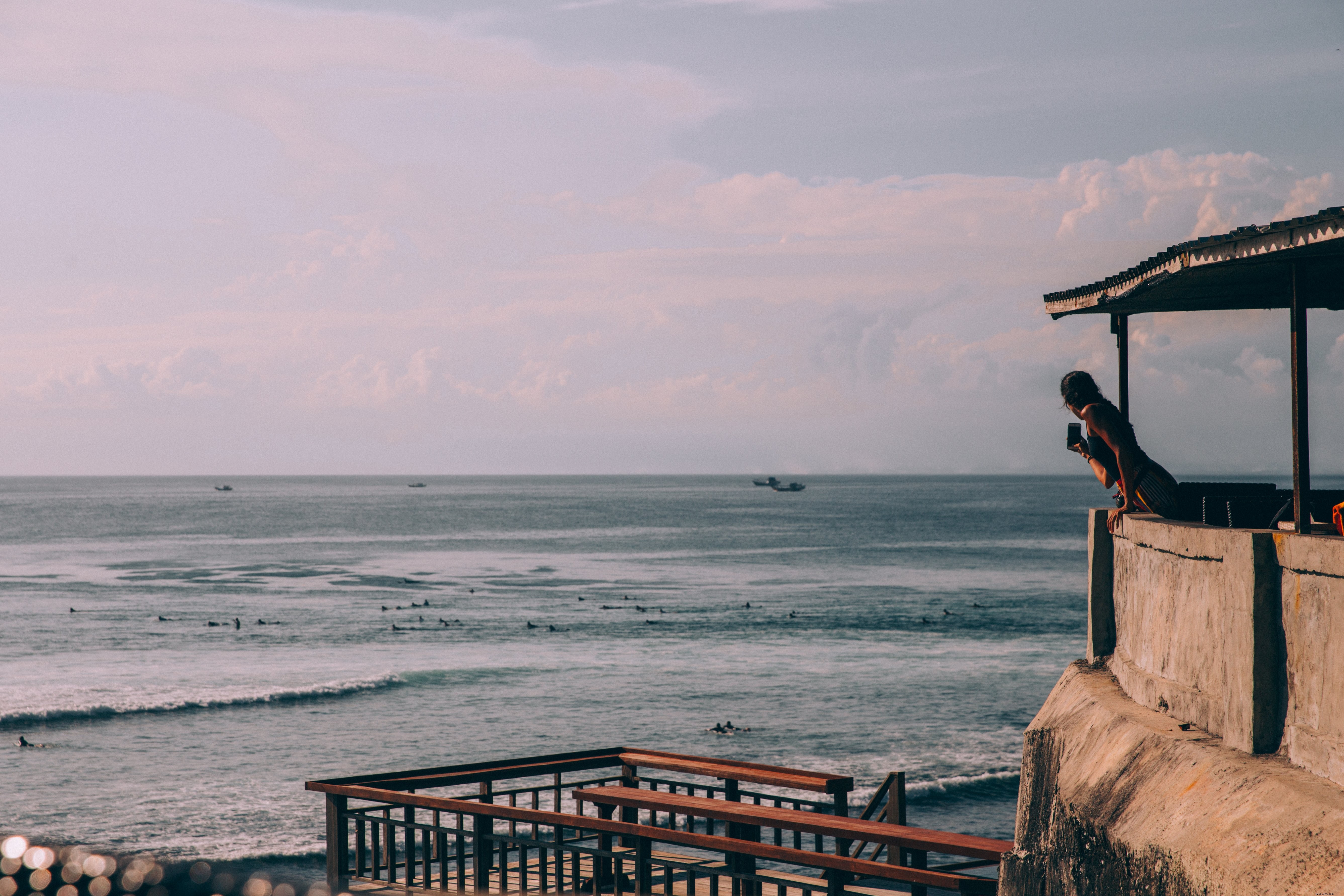 Femme photographiant la plage avec son téléphone