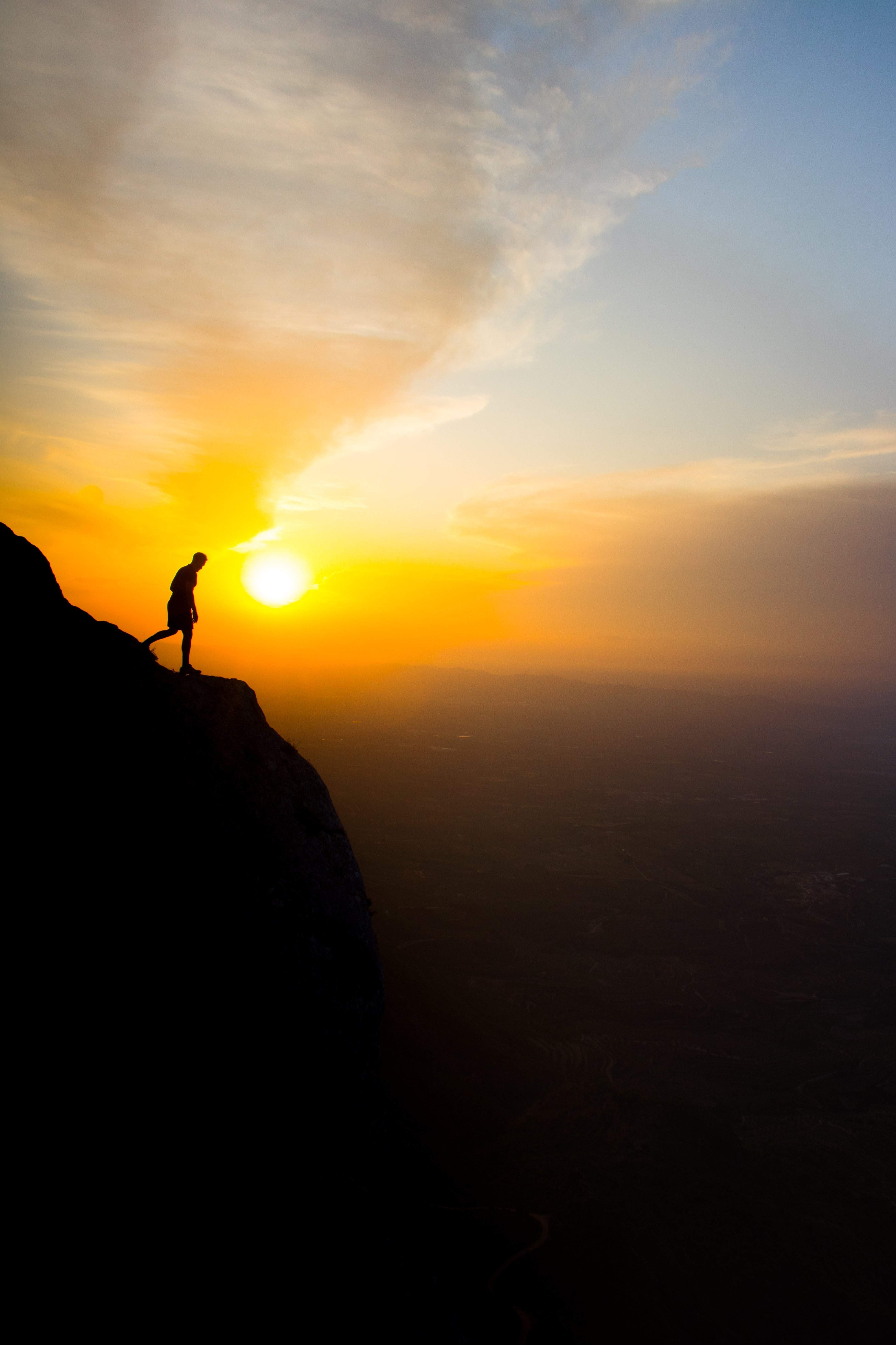Silhouette d une personne debout sur une falaise au coucher du soleil