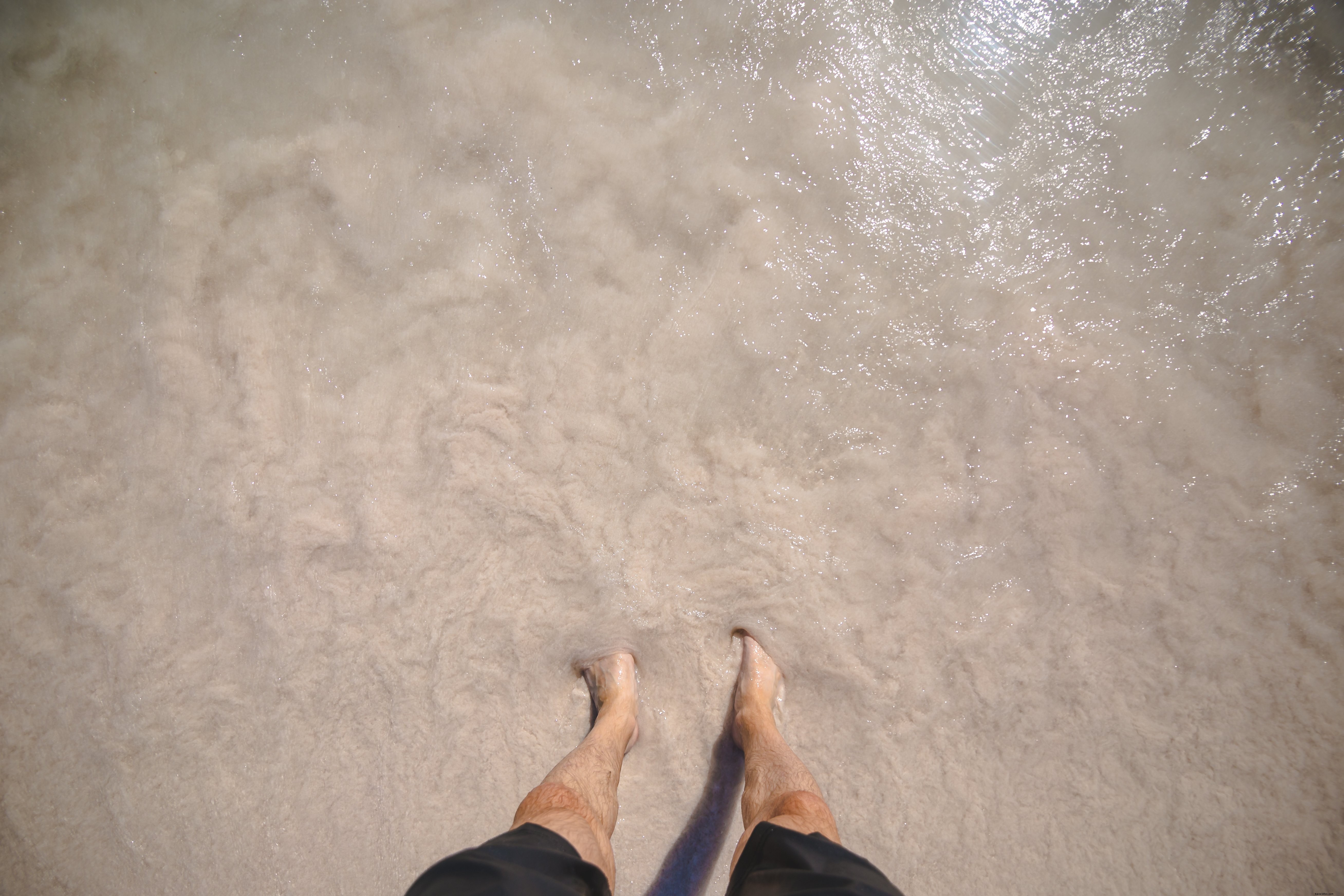 Photo d un homme aux pieds dans l eau sur la plage
