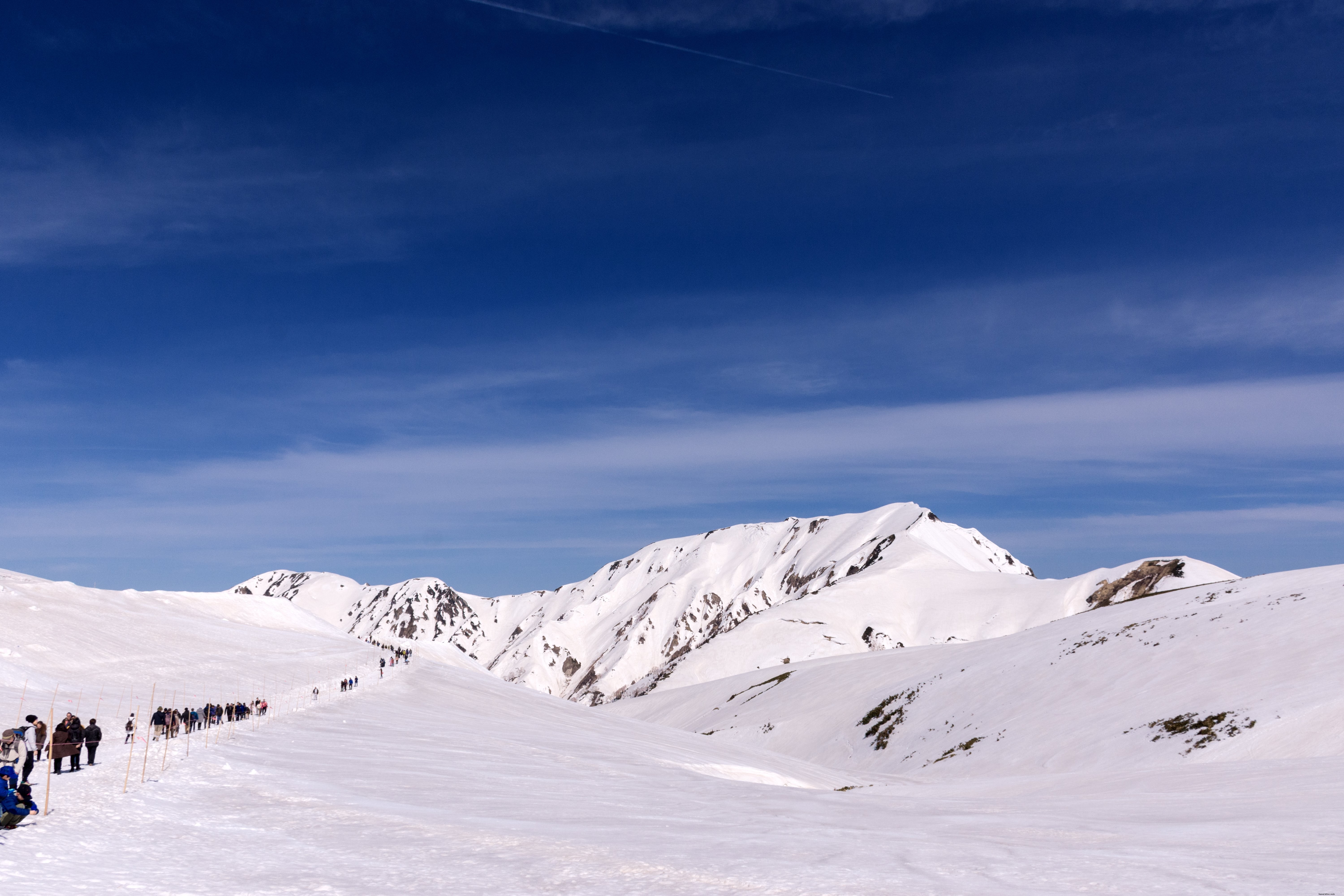 Une bande de randonneurs traverse les montagnes enneigées