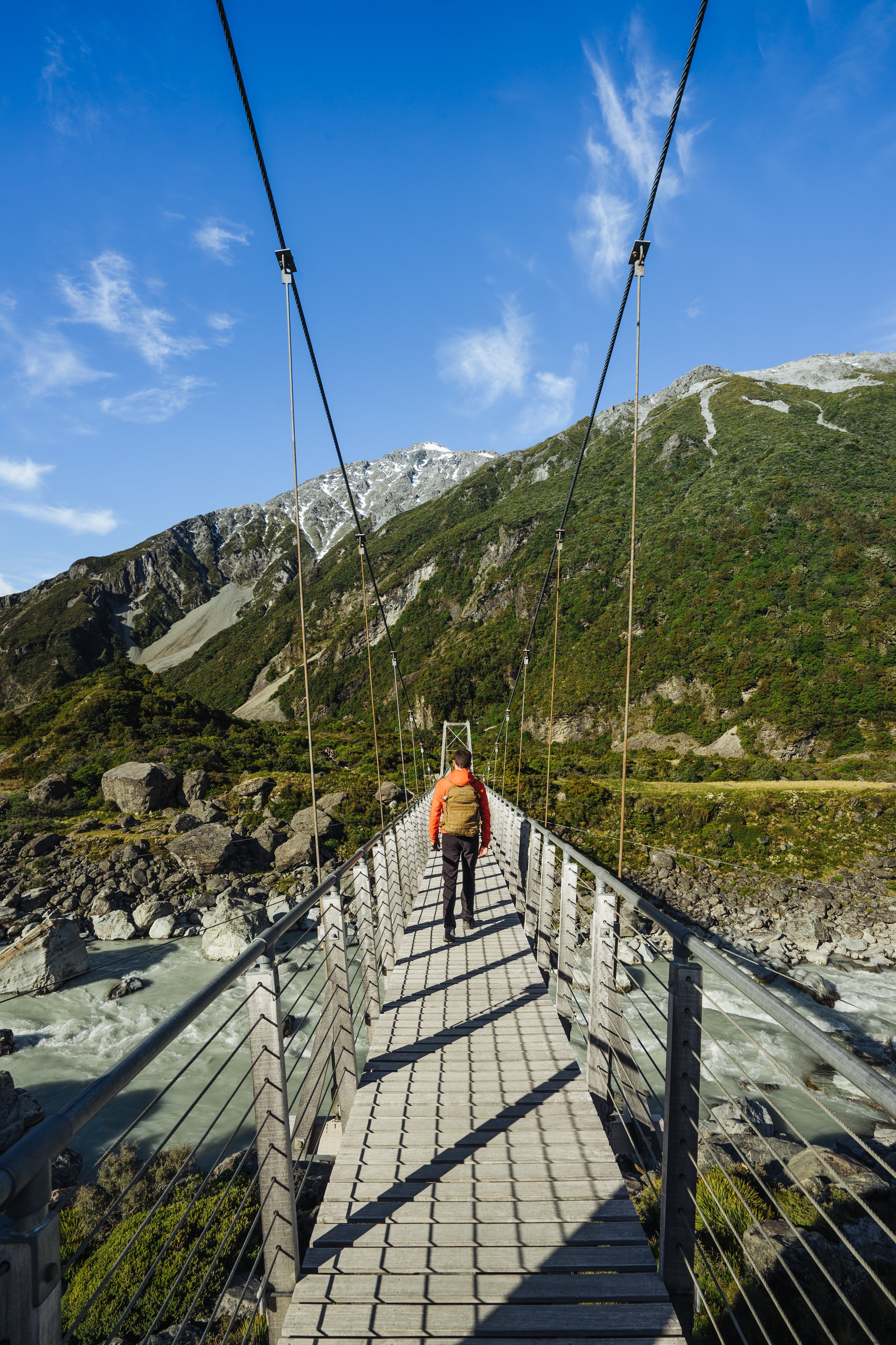 Photo d’un homme traversant un pont suspendu