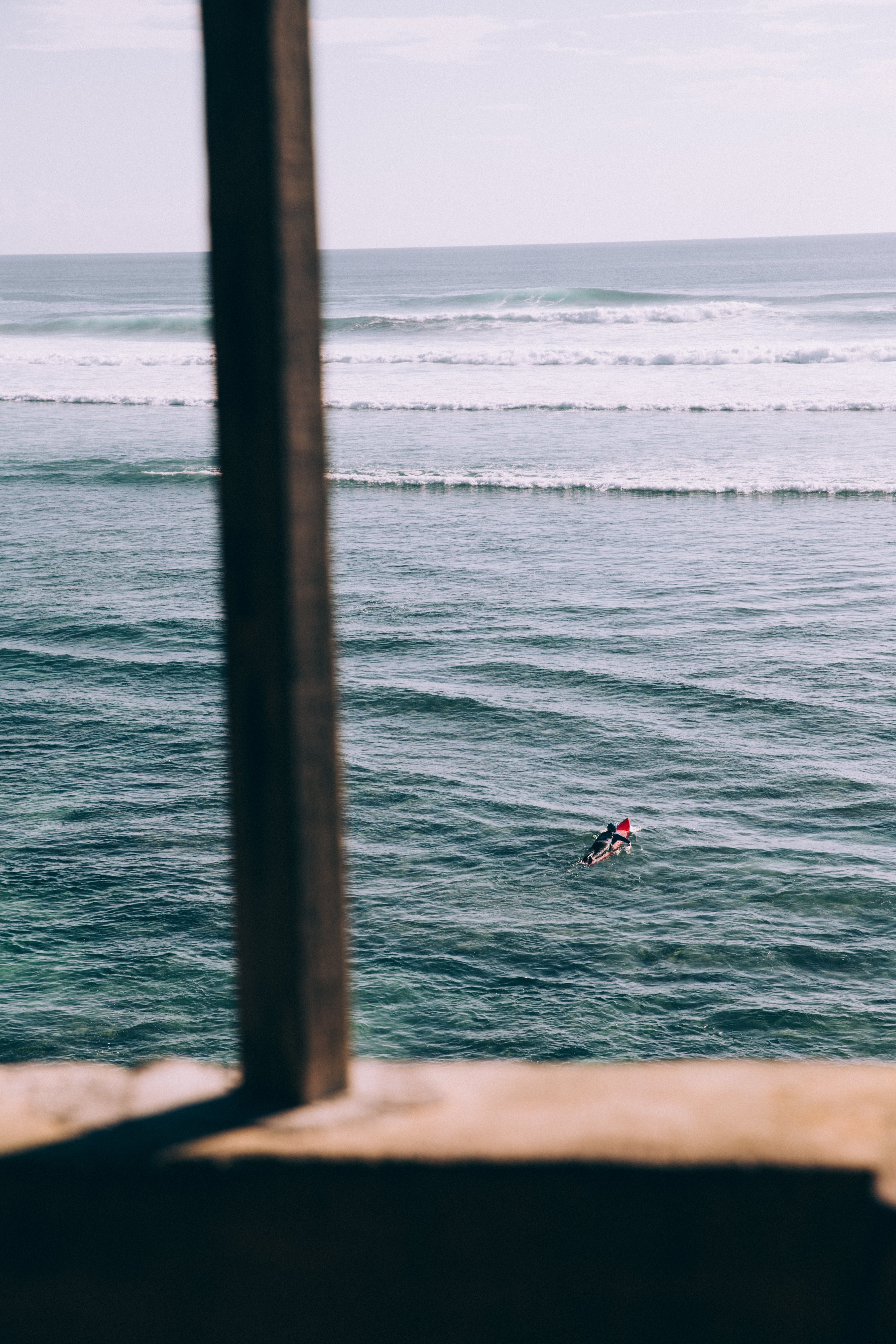 Un surfeur solitaire pagaye vers les vagues – Photo