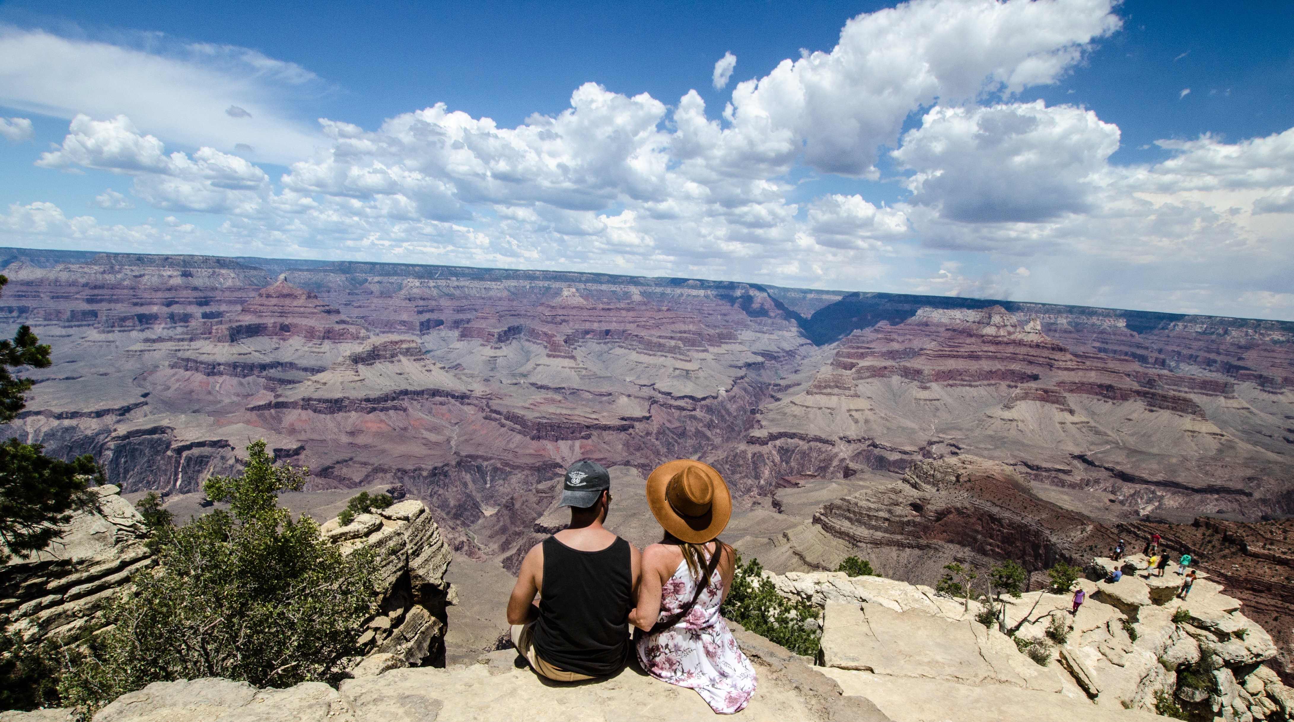 Un jeune homme et une femme discutent devant une photo de canyon
