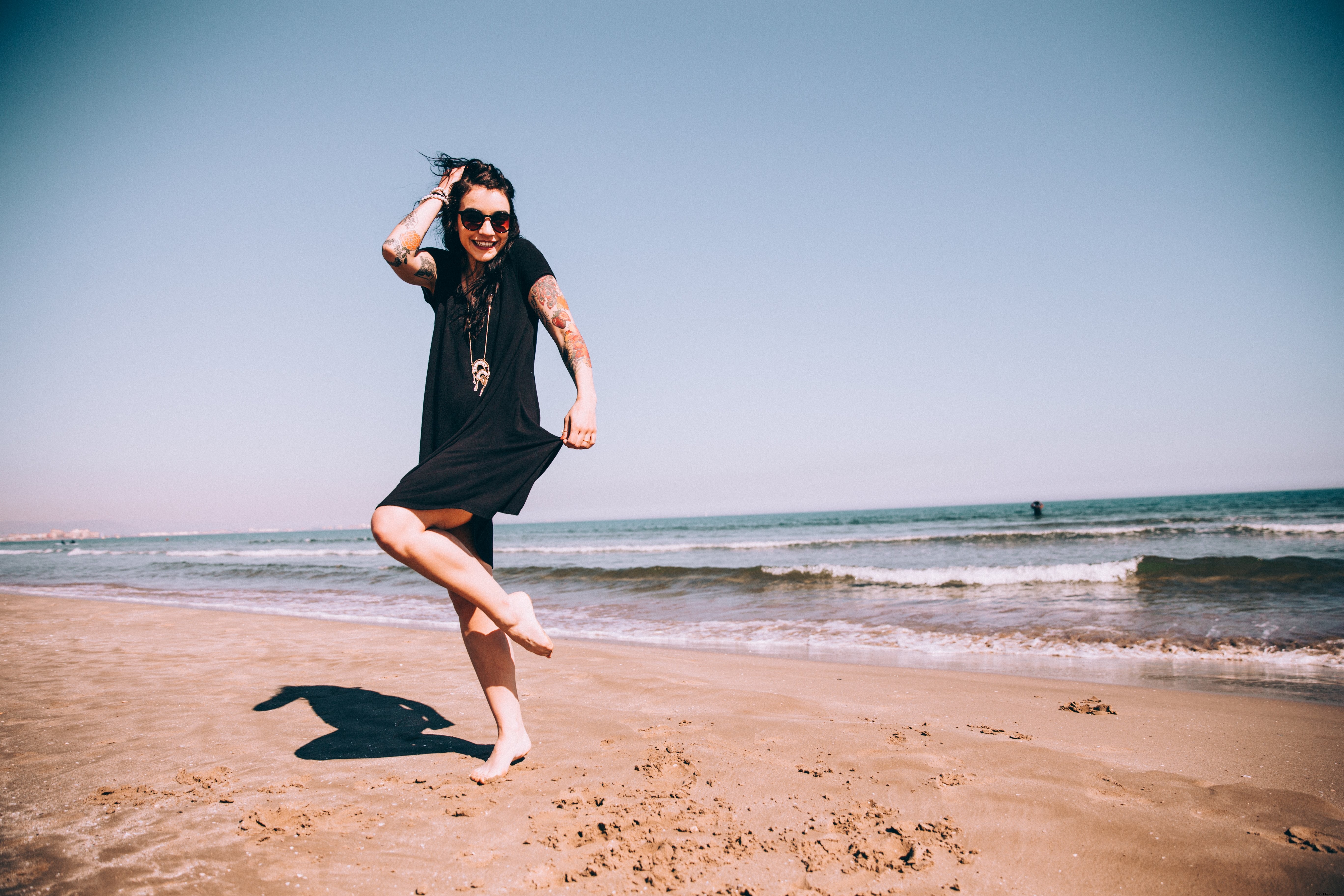 Photo : une femme tatouée profitant du soleil sur la plage