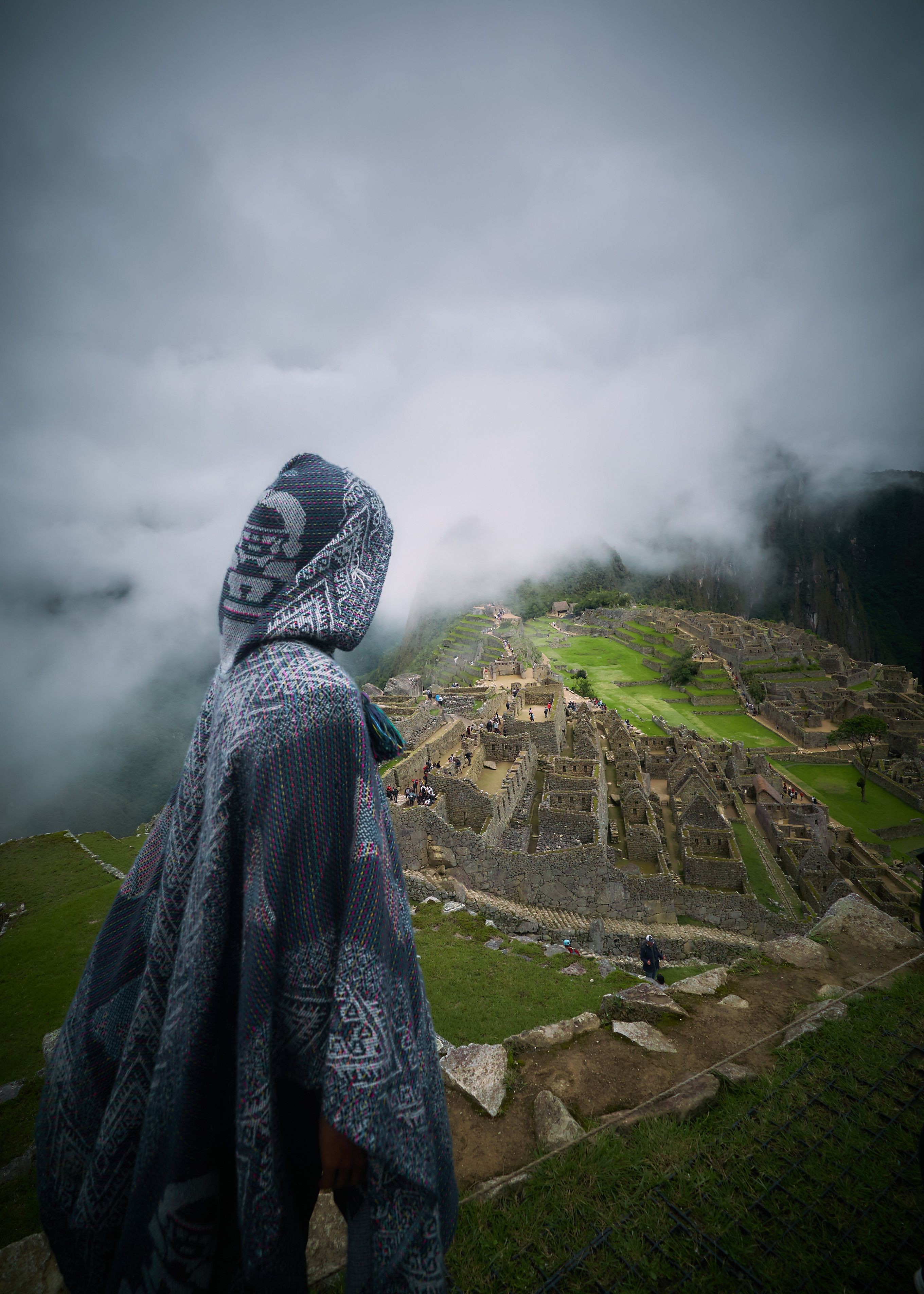Photo d’une personne cagoulée face aux ruines