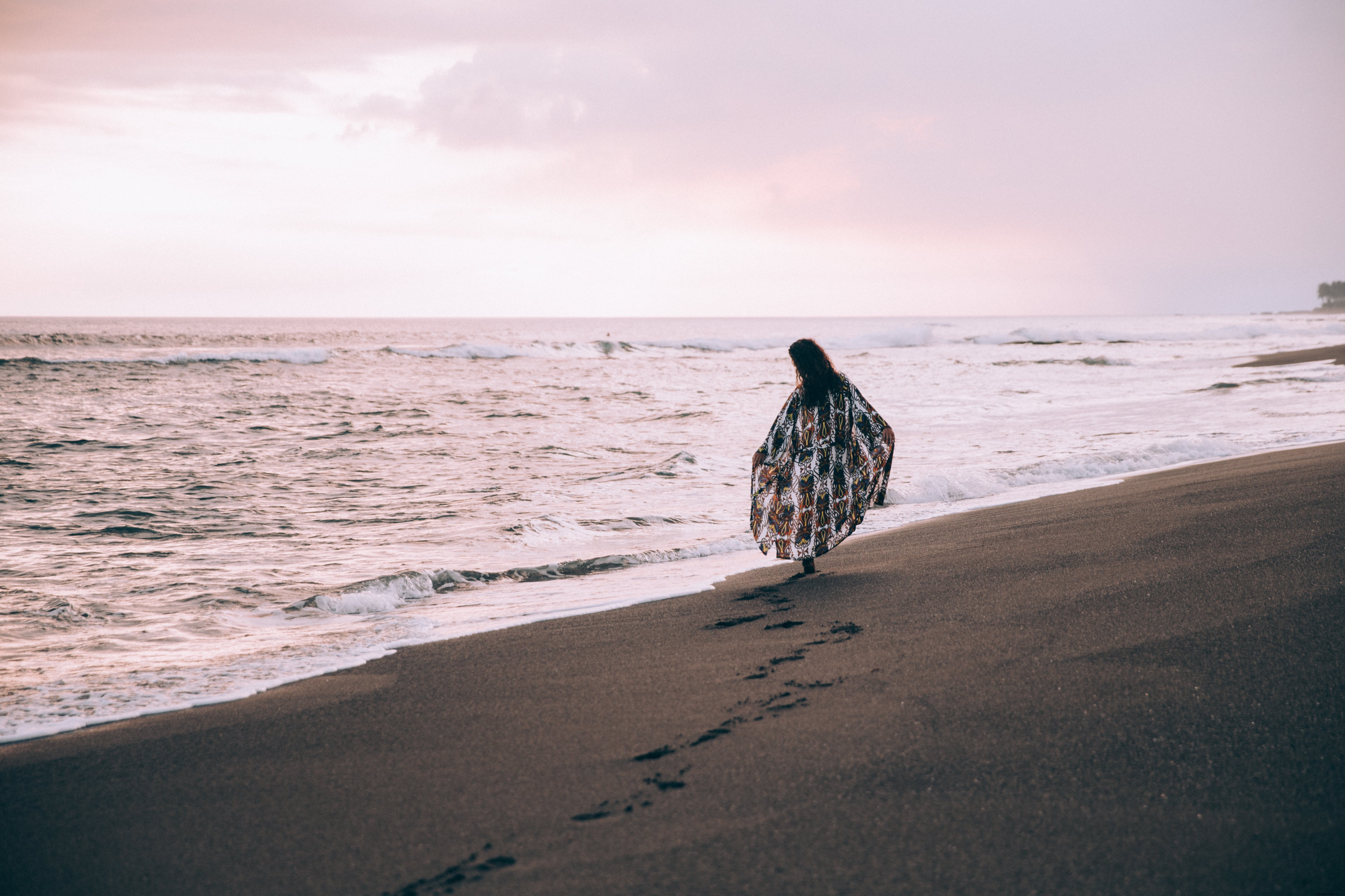 Femme marchant sur la plage, laissant des empreintes dans le sable
