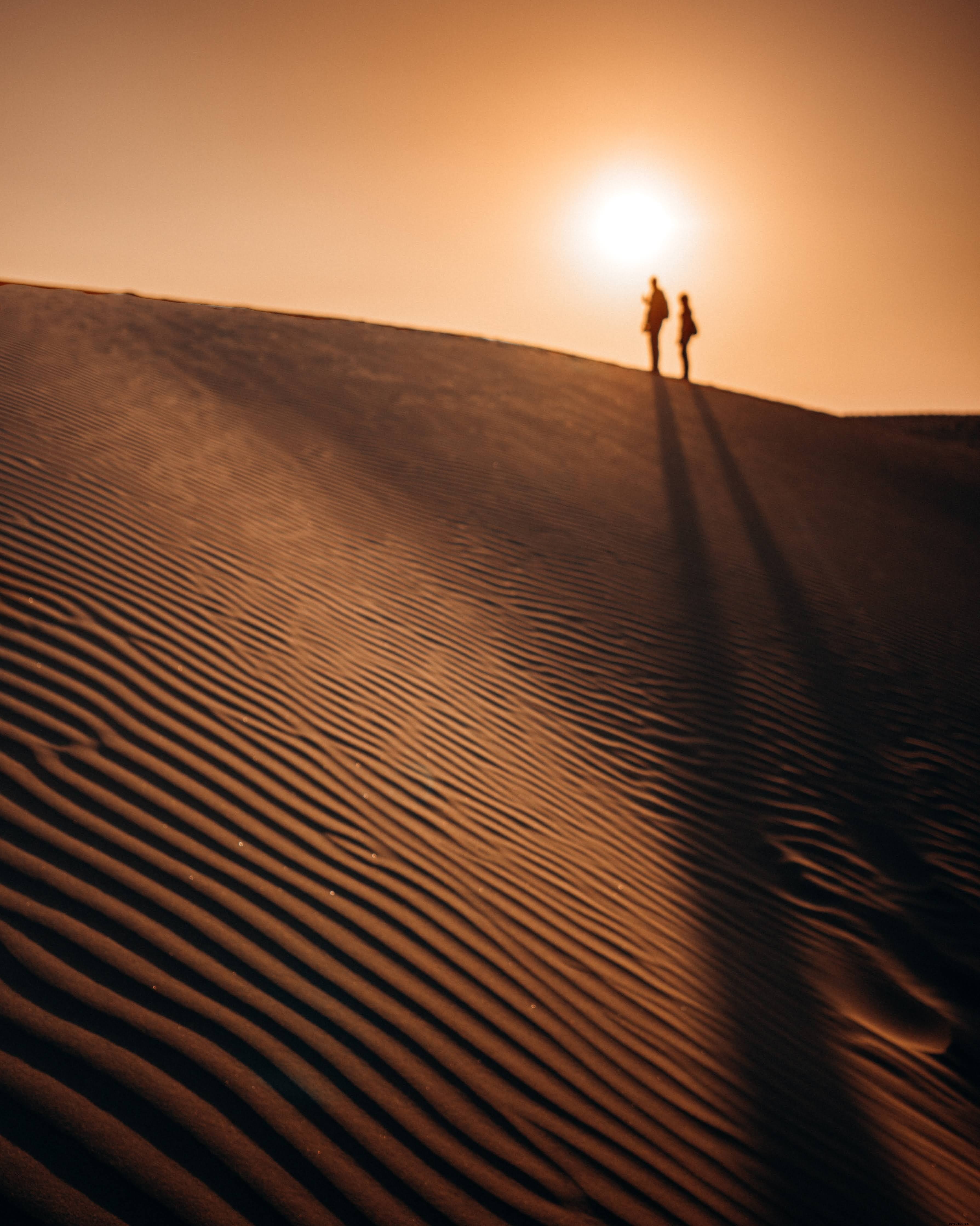 Silhouettes humaines au sommet des dunes de sable