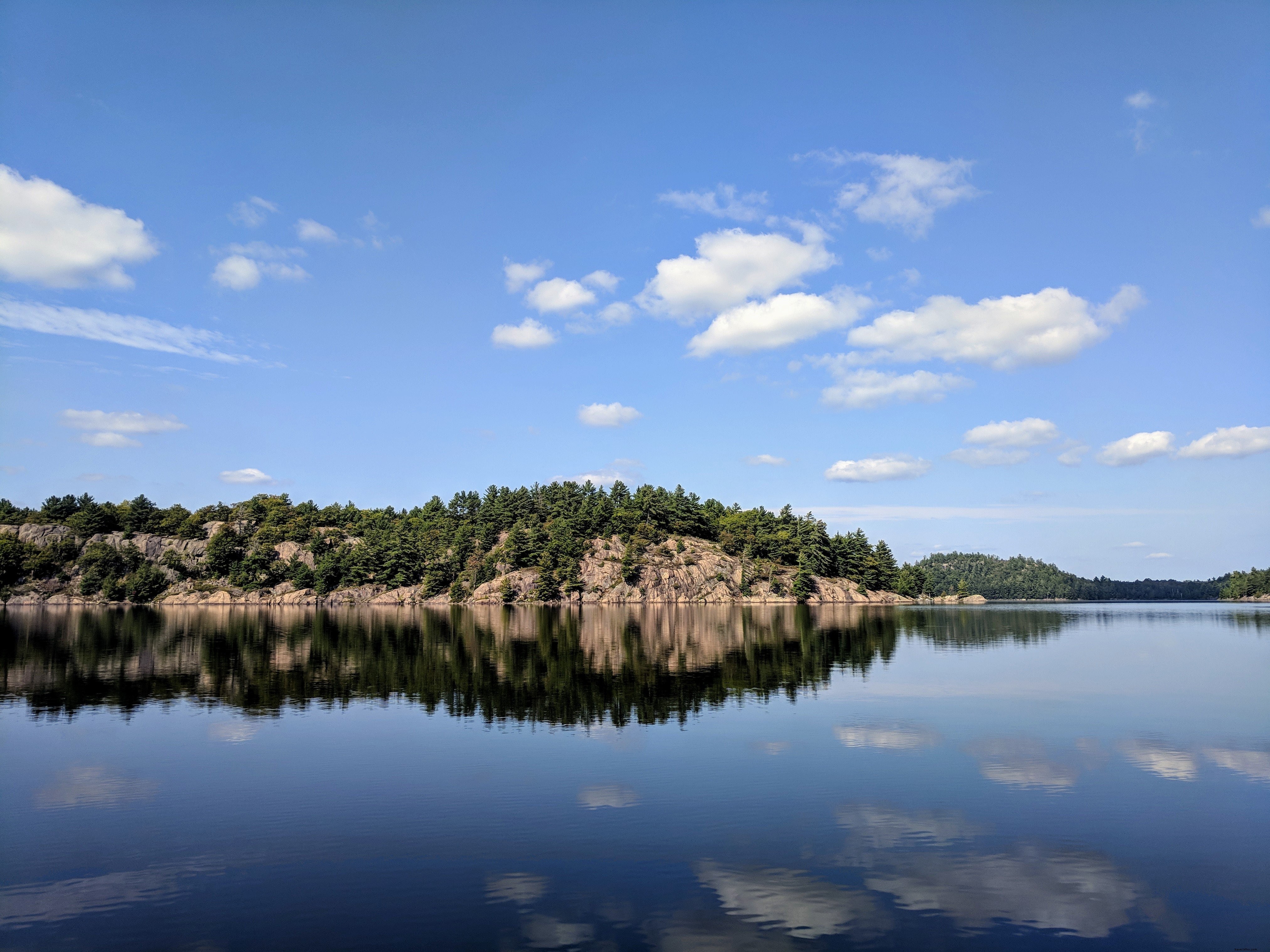 Reflet des rochers et des arbres sur le lac