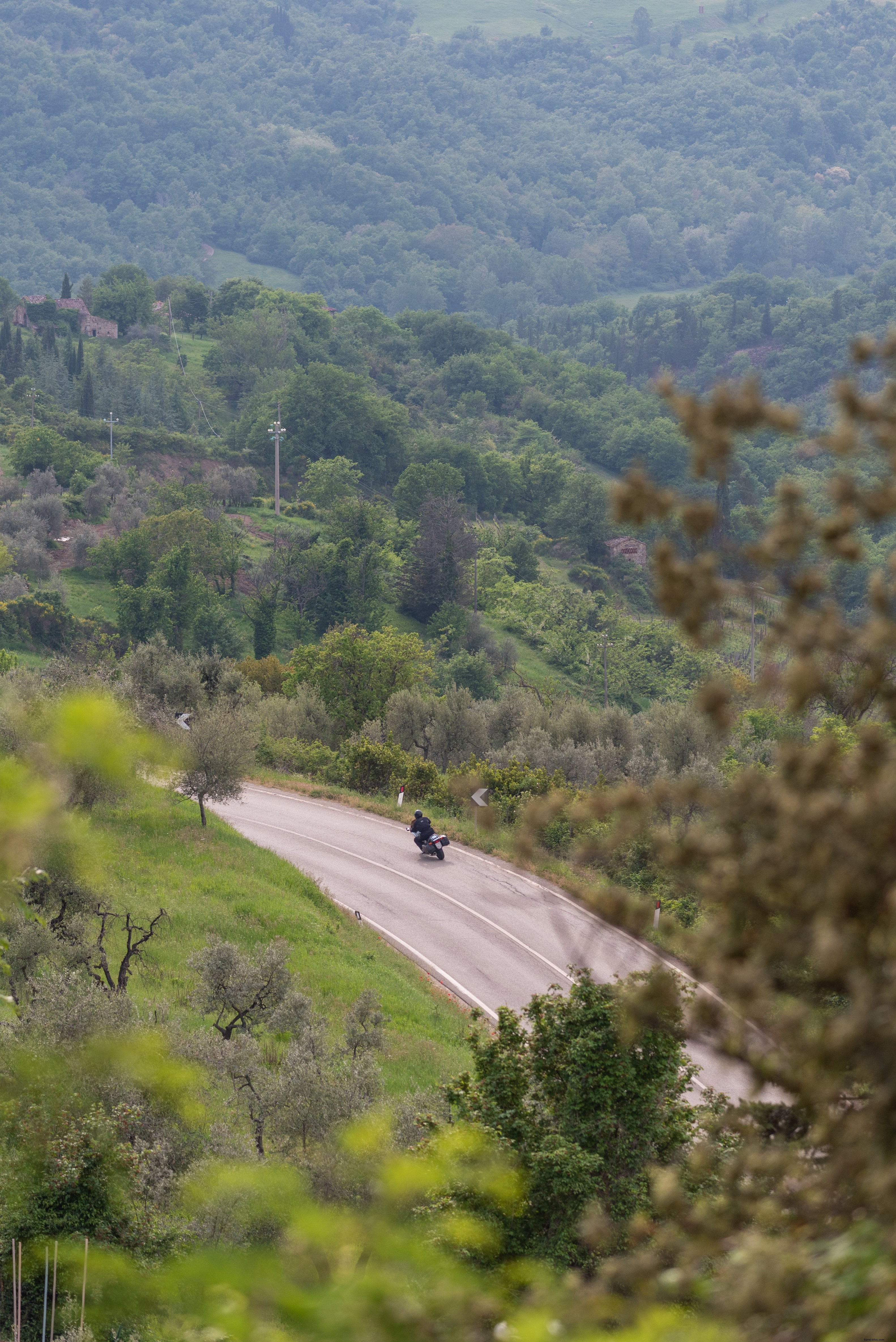 Une moto prend la courbe d’une autoroute près d’une colline