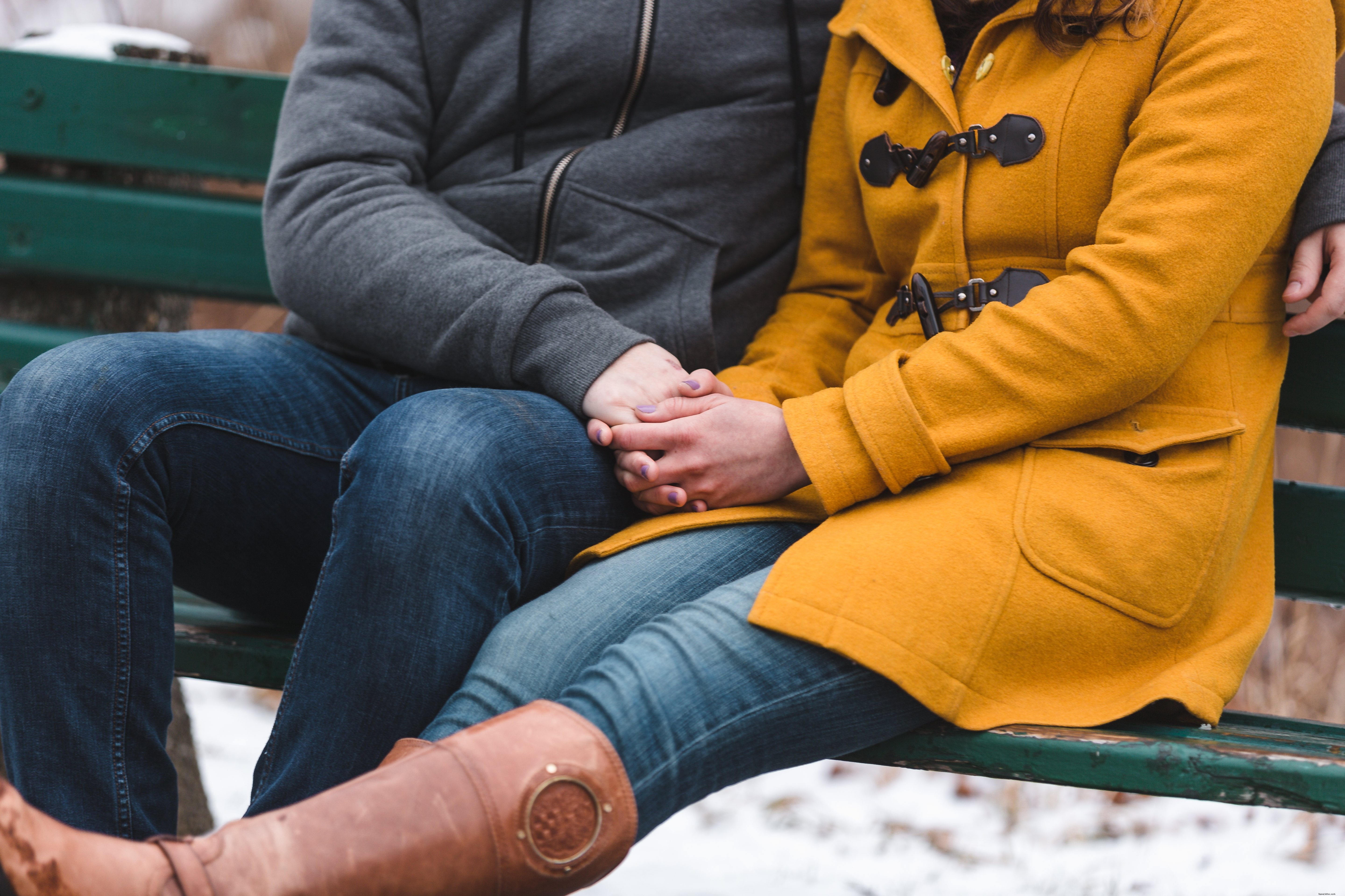 Un couple se serre les uns contre les autres pour se réchauffer sur un banc