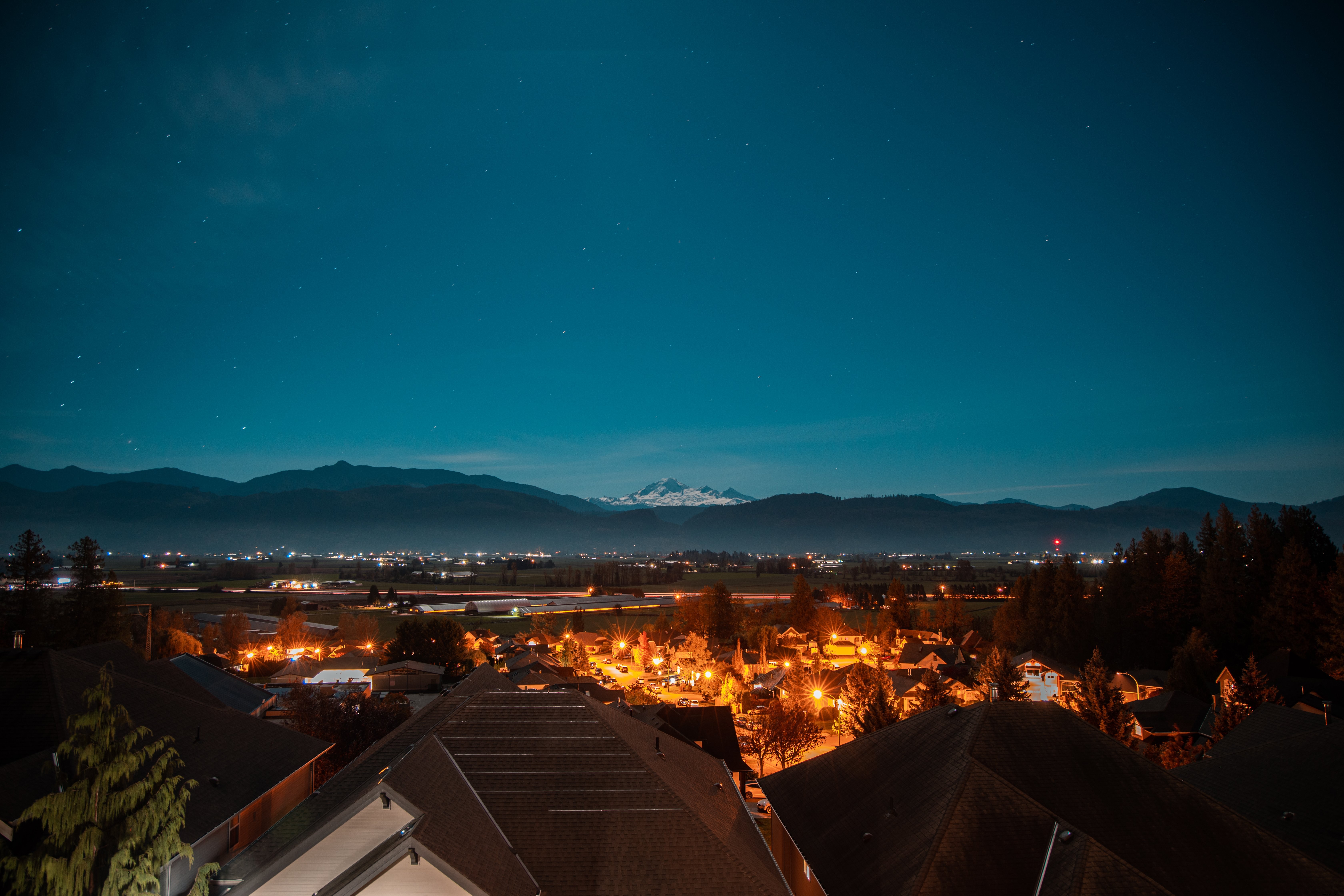 Vue de la ville sur les montagnes enneigées sous un ciel étoilé