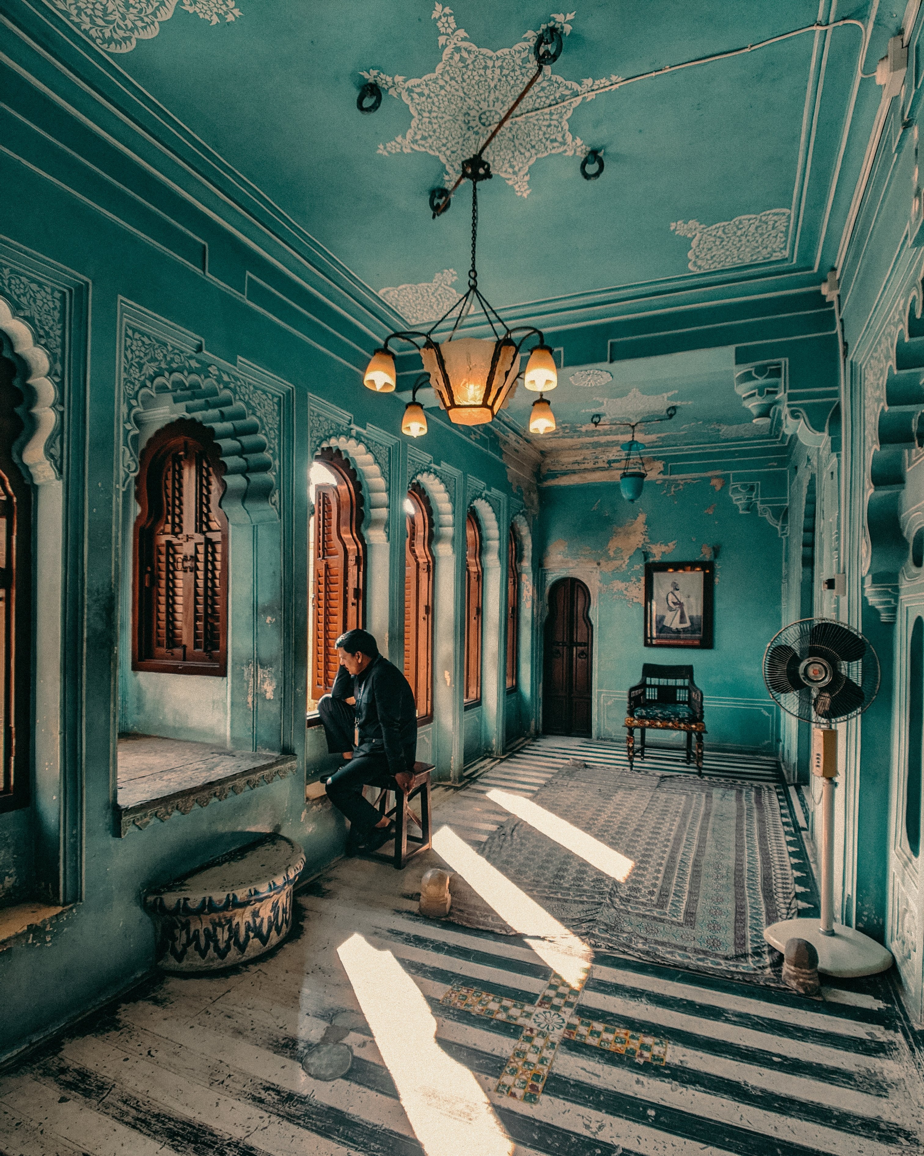 Un homme assis dans le couloir bleu décoré