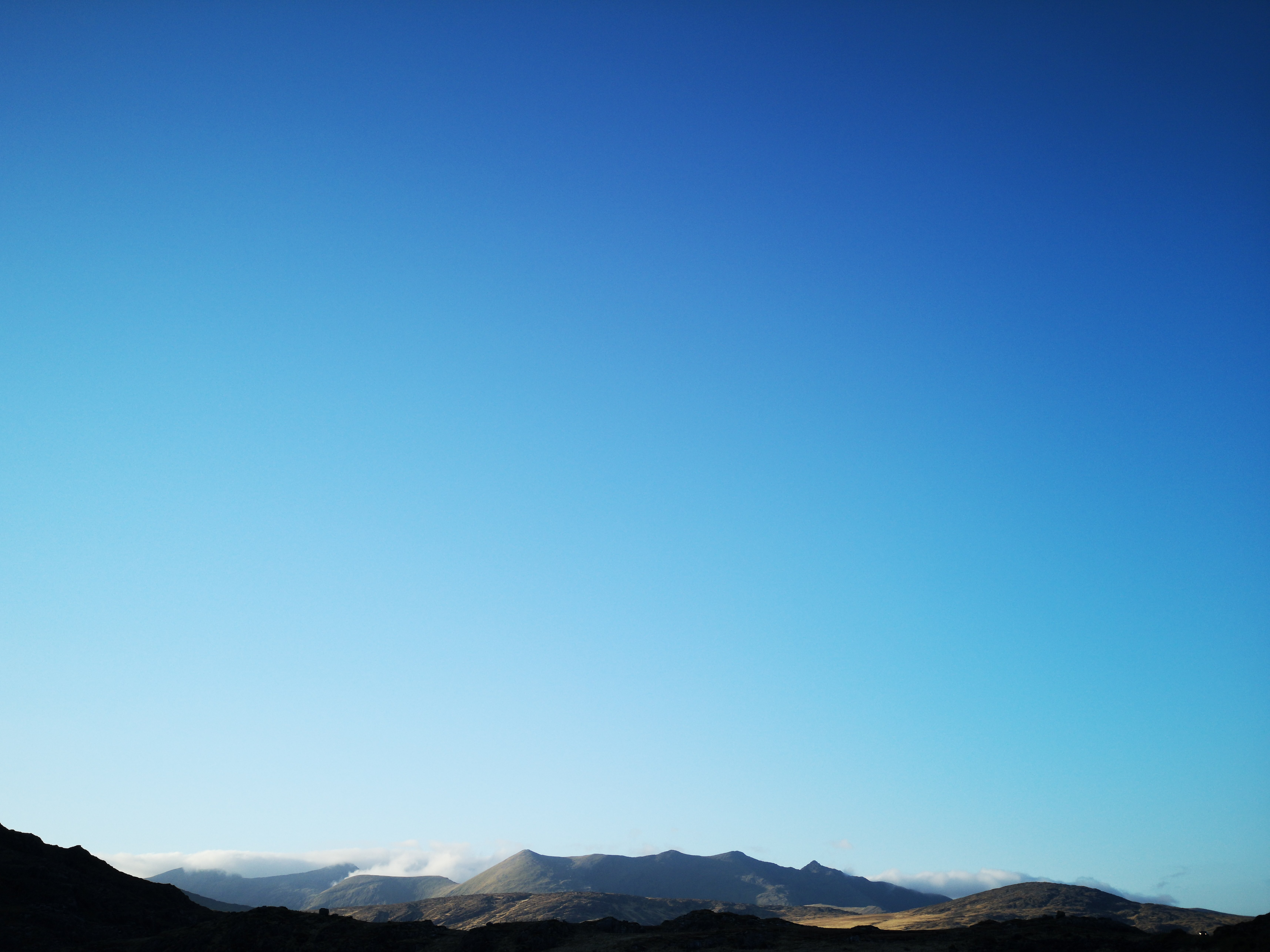 Photo du ciel bleu au‑dessus des montagnes ensoleillées
