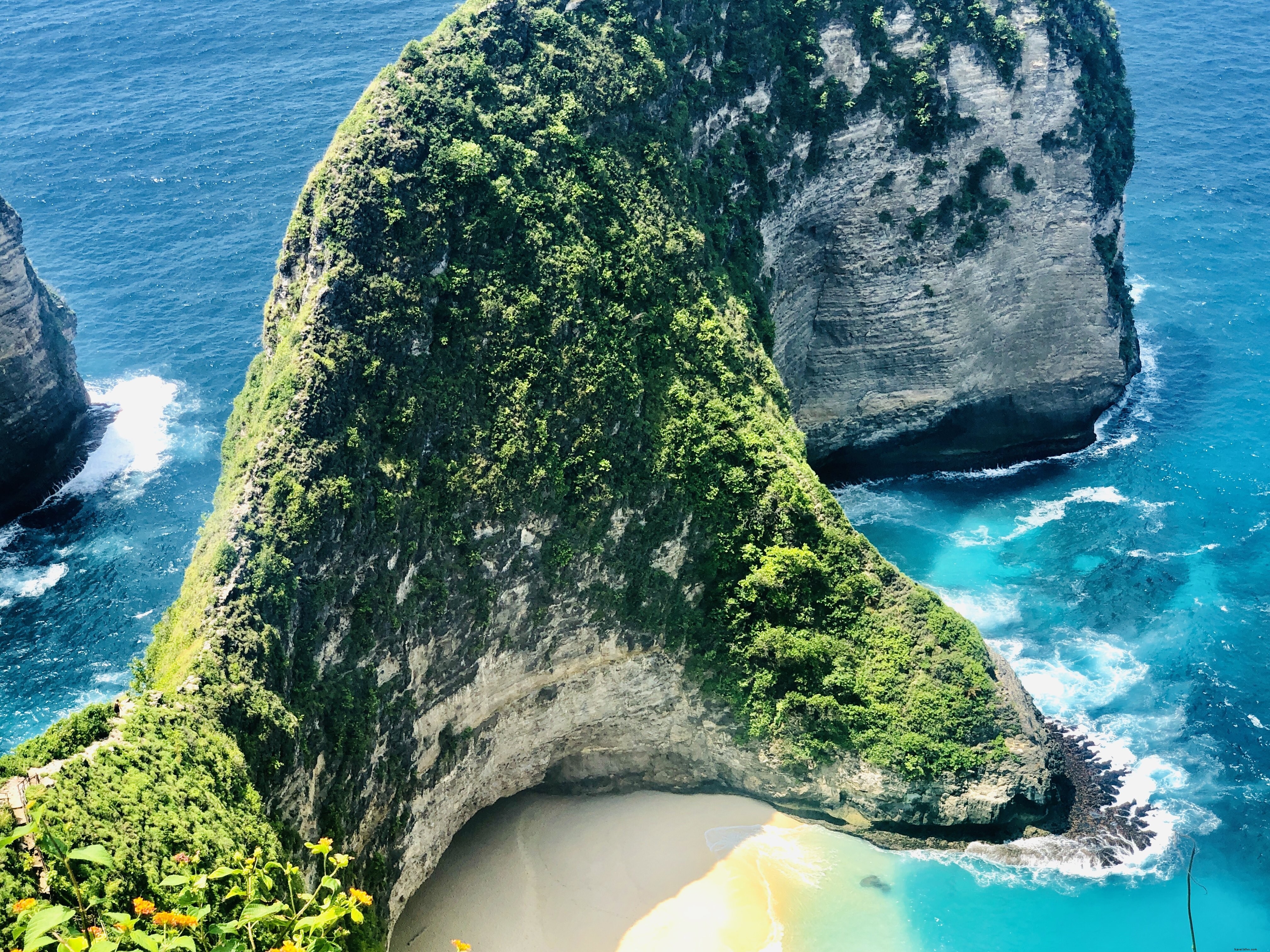 Une falaise verdoyante encadre une photo de plage
