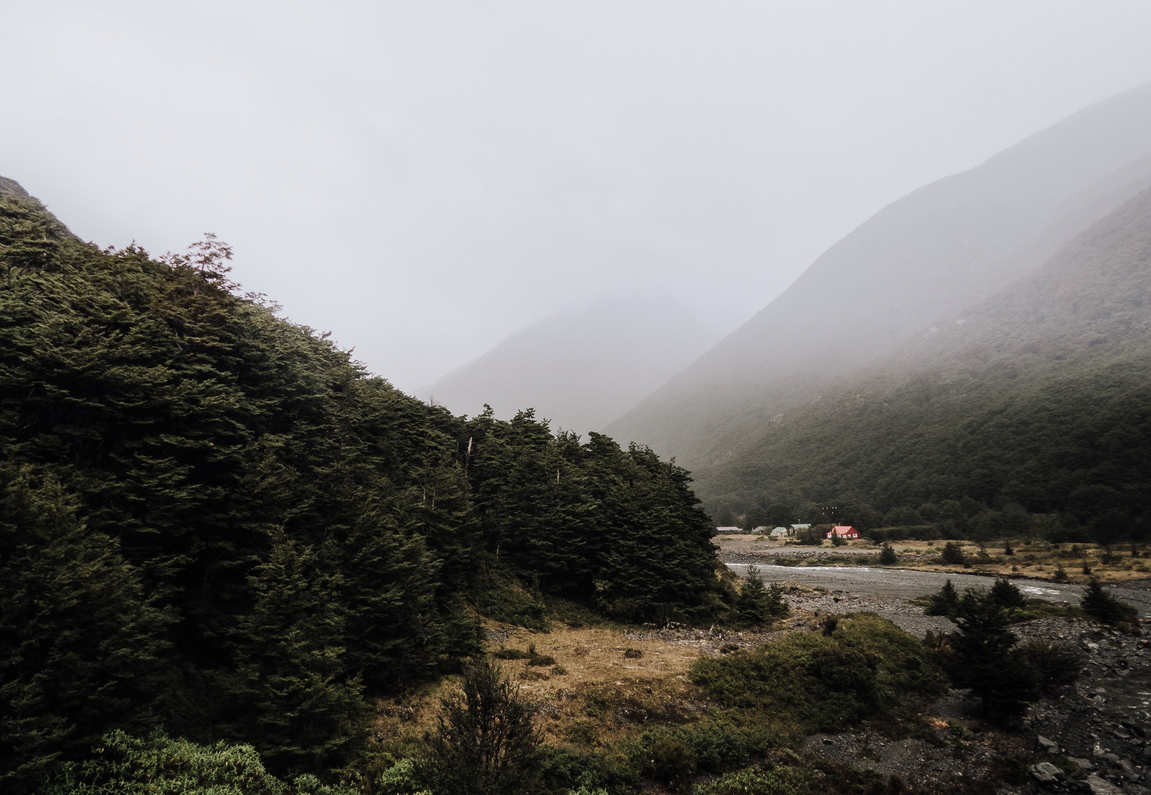 Image d’une vallée de montagne embrumée et de huttes forestières