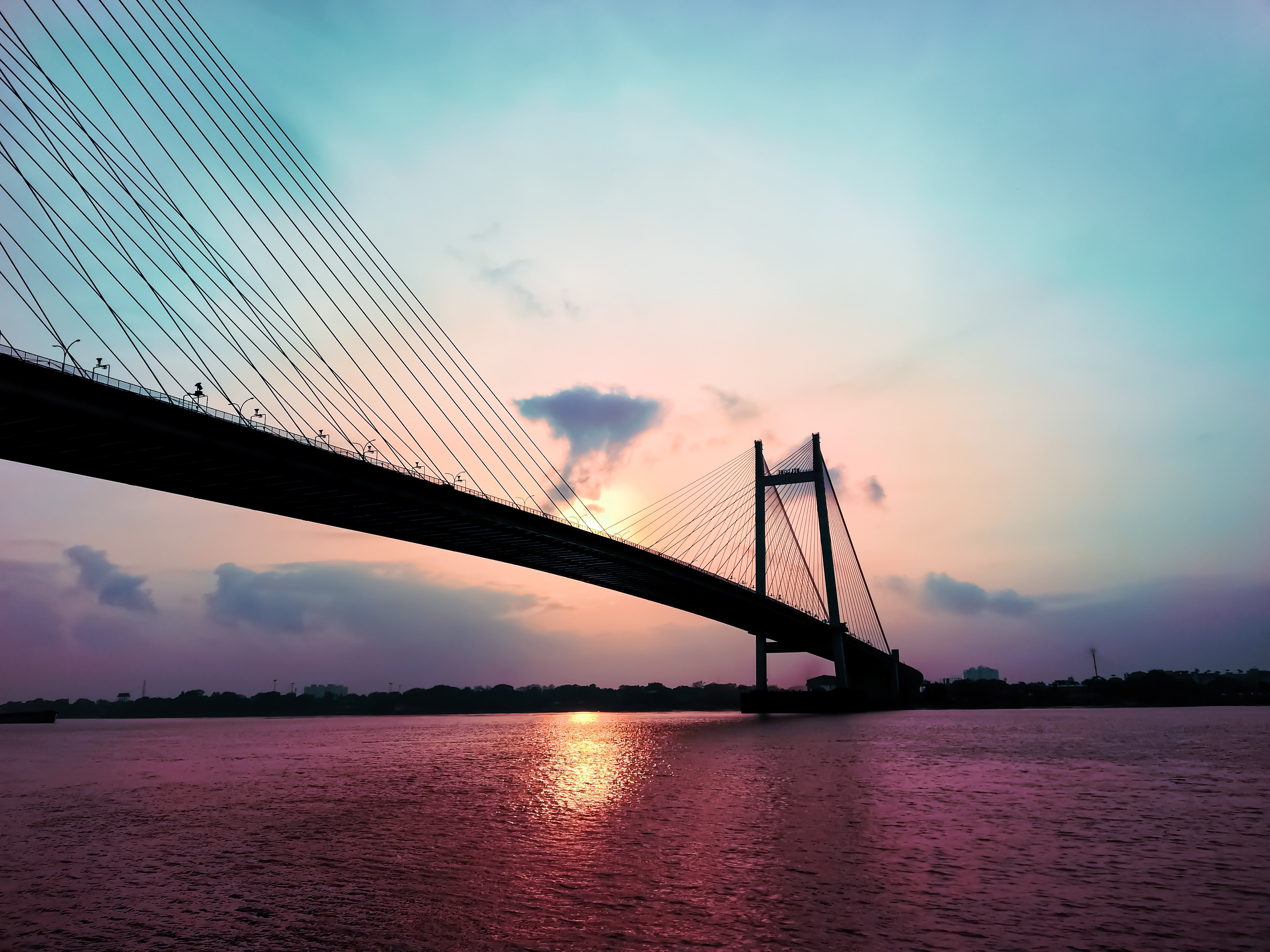 Photo d un pont suspendu silhouetté au coucher du soleil