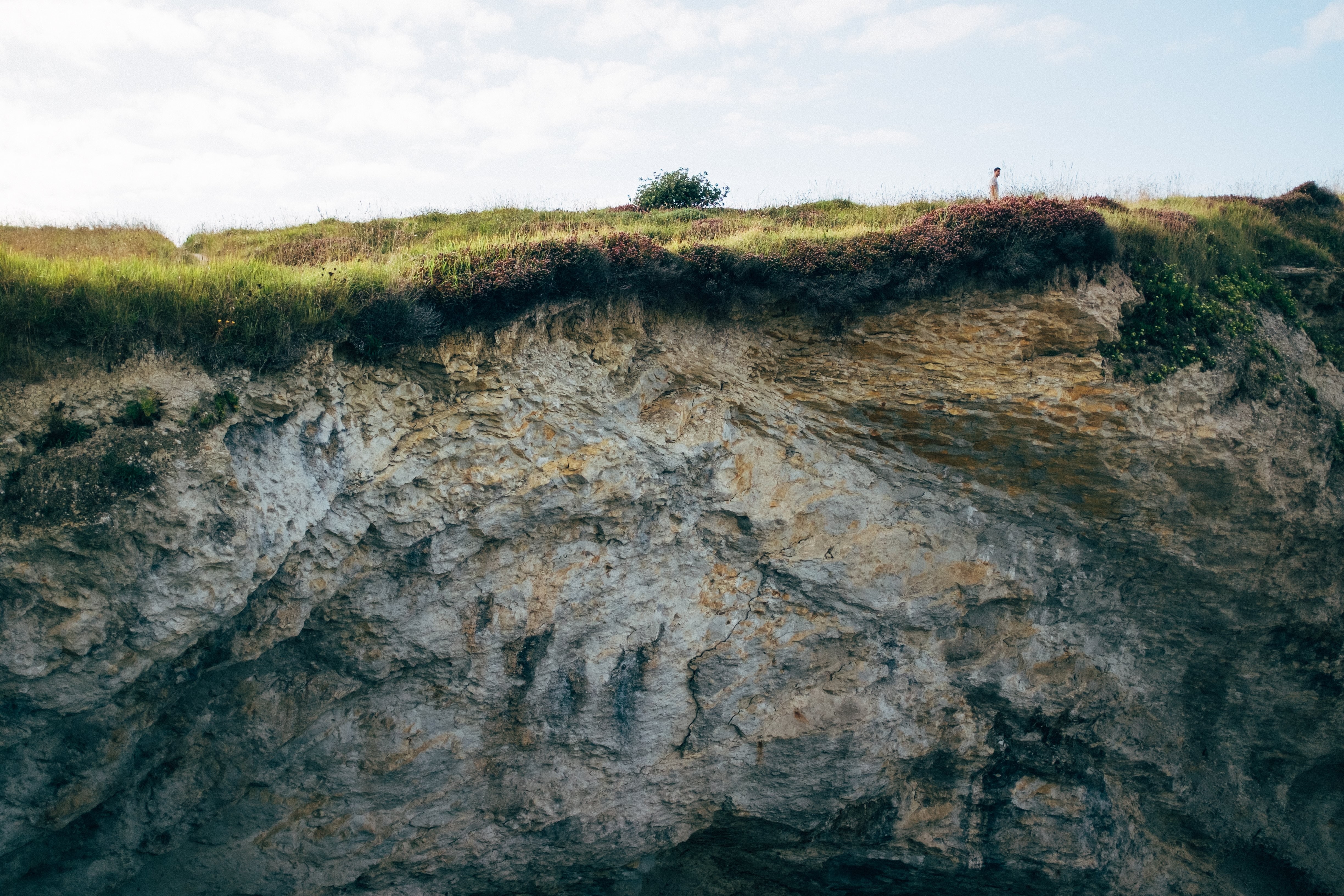 Petite silhouette d un homme marchant sur la colline au sommet d une falaise