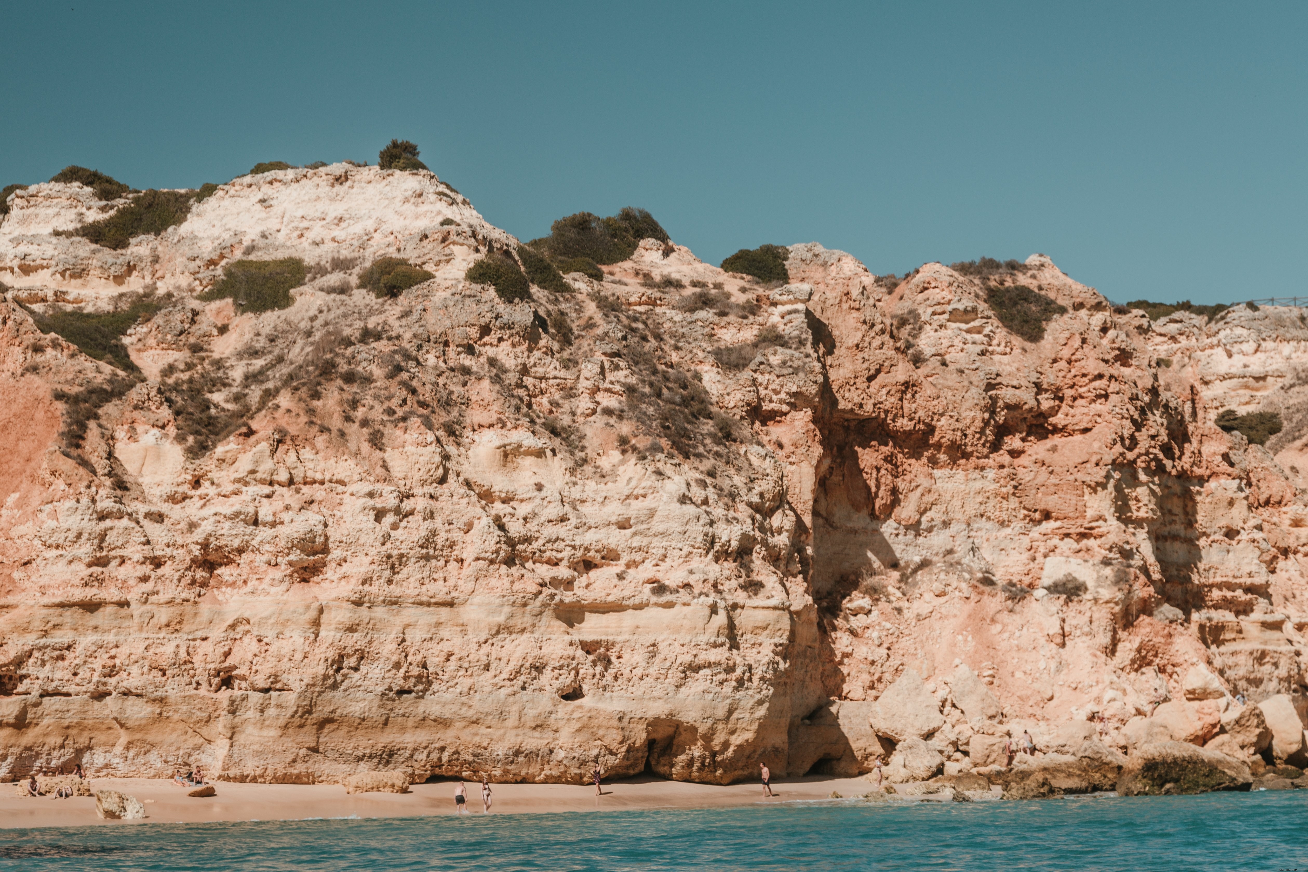 Photo des falaises ensoleillées dominant la plage de sable