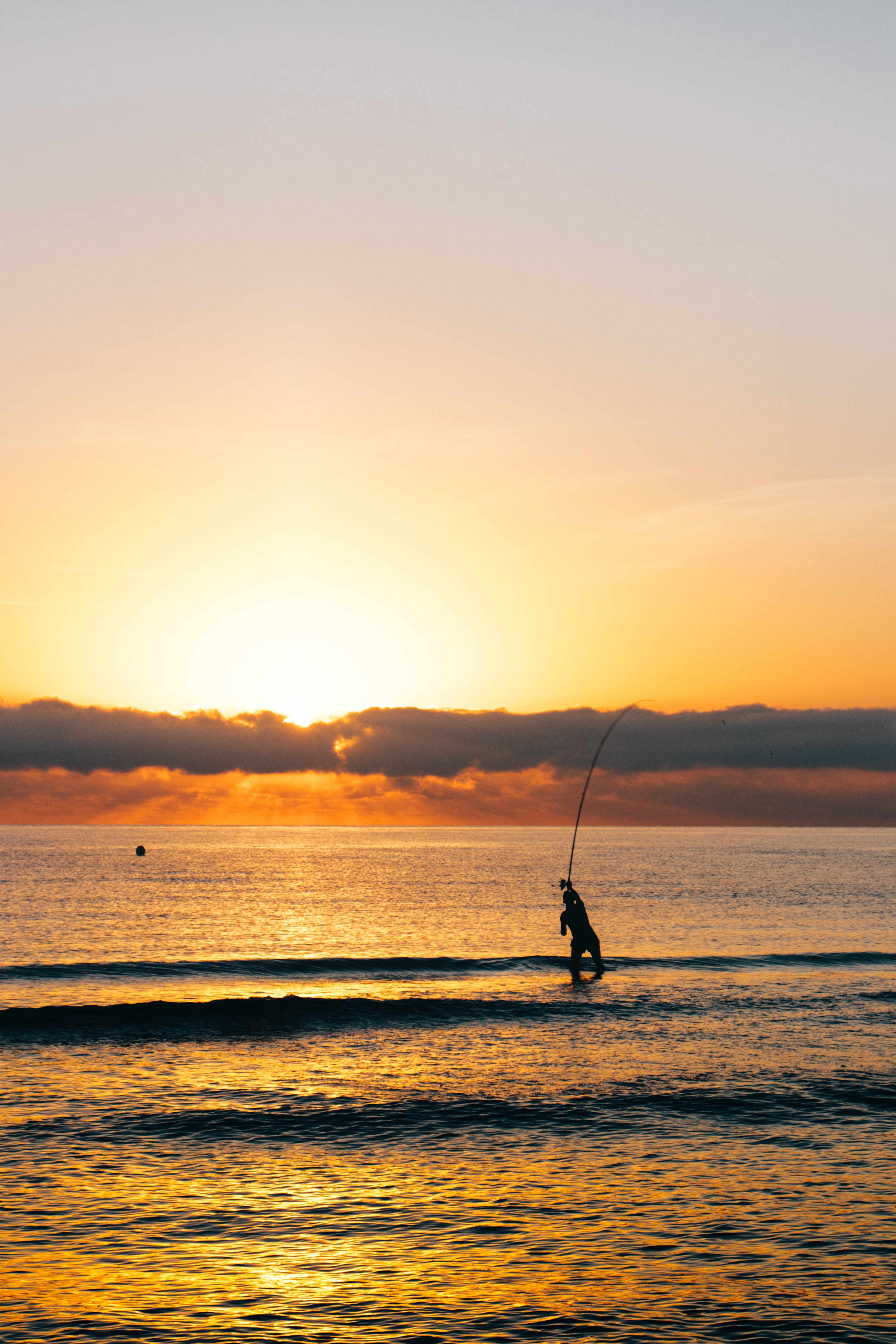 Photo d’un pêcheur au lever du soleil