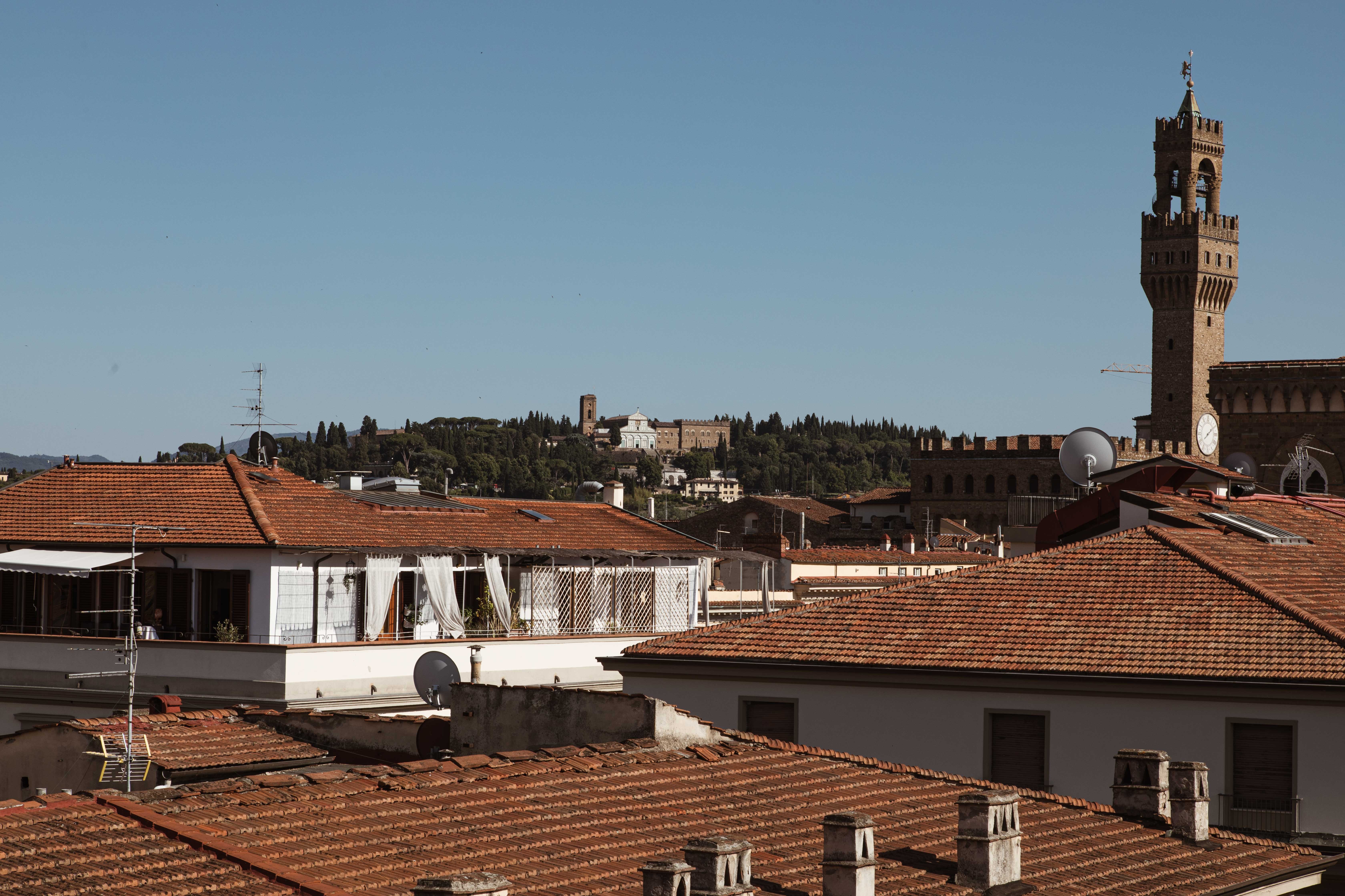 Photo d’un clocher d’église perché sur des toits en terre cuite