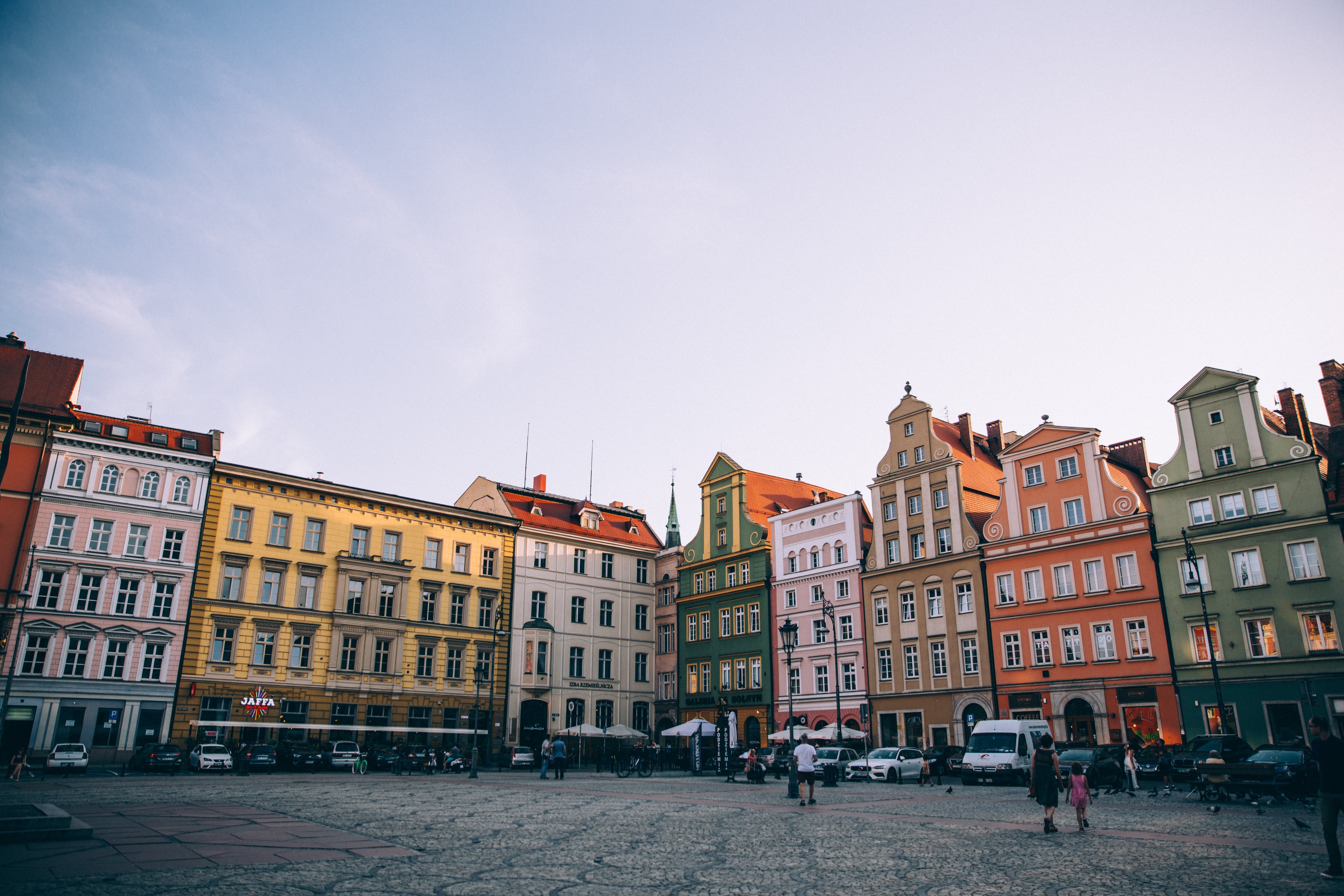 Coucher de soleil sur une place d une ville européenne entourée de bâtiments colorés