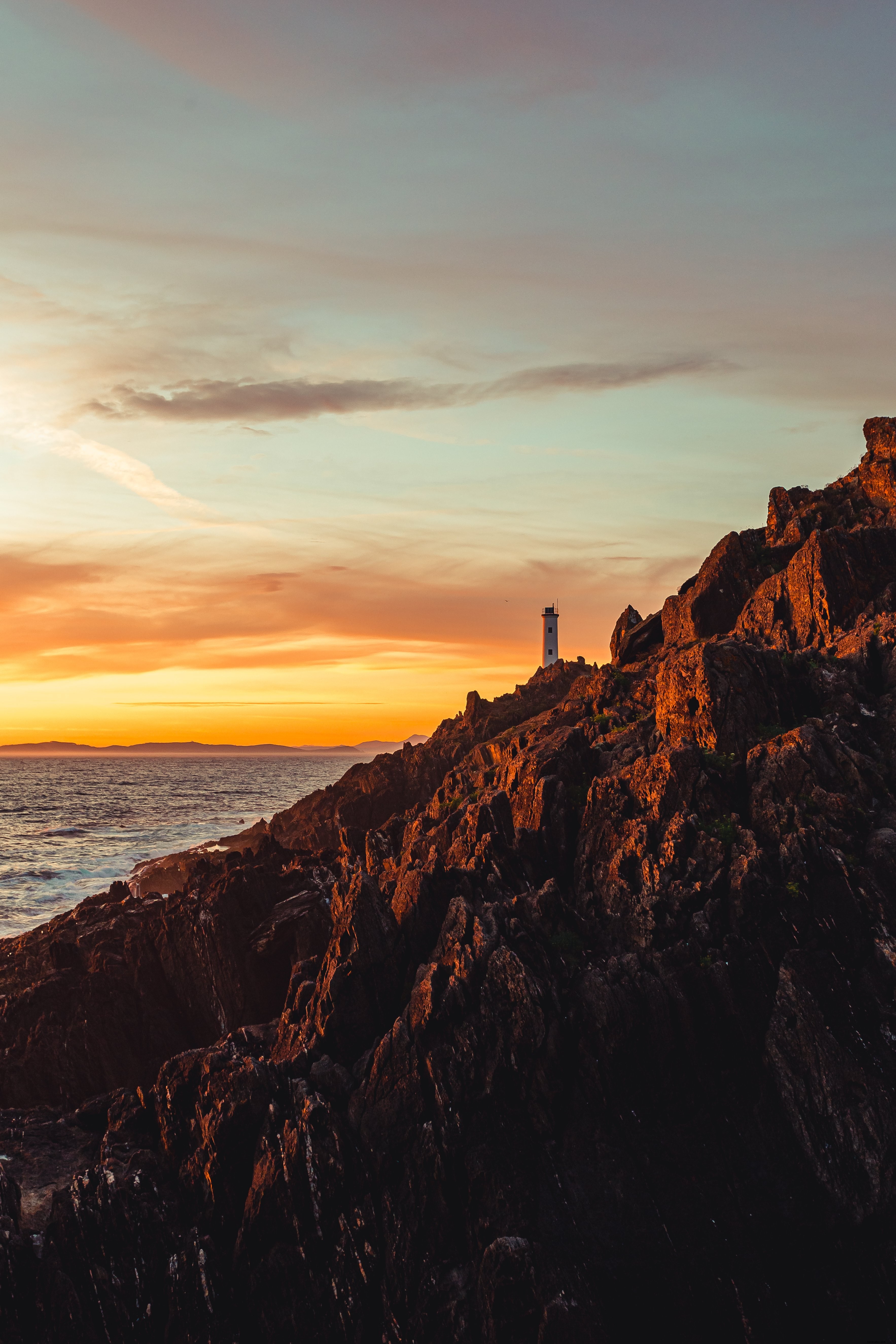 Photo d’un phare perché sur une falaise escarpée