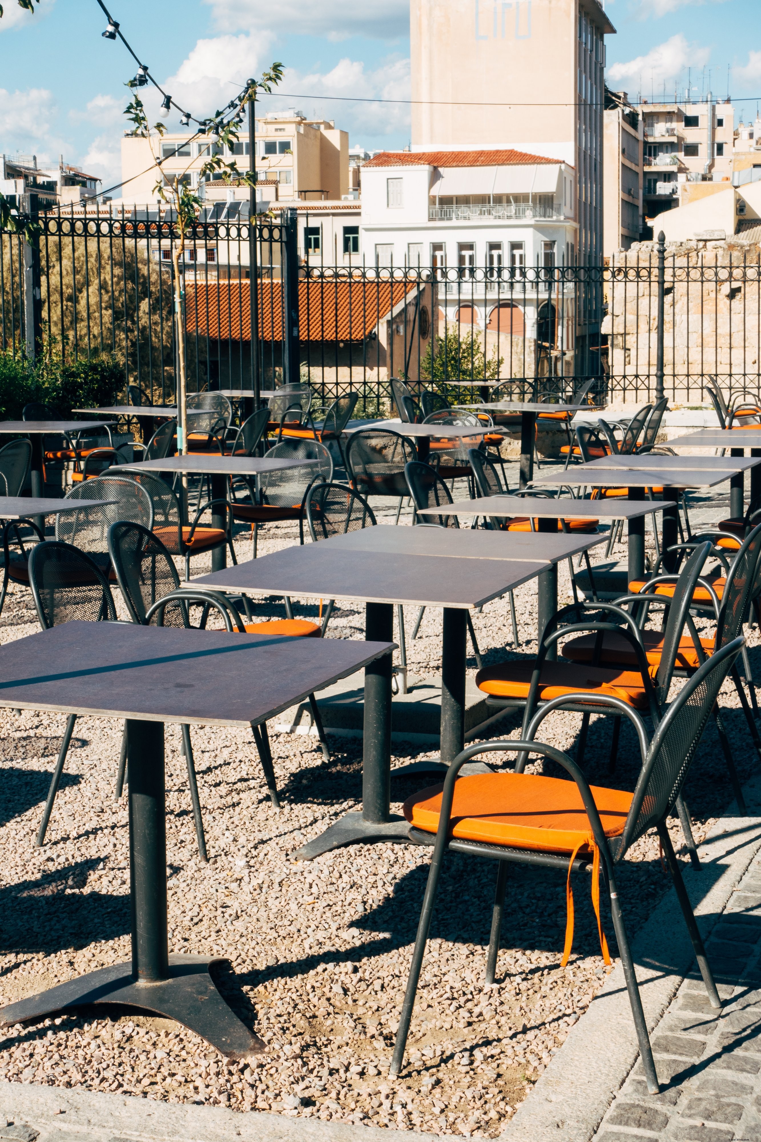 Coussins orange sur des chaises métalliques dans un patio désert