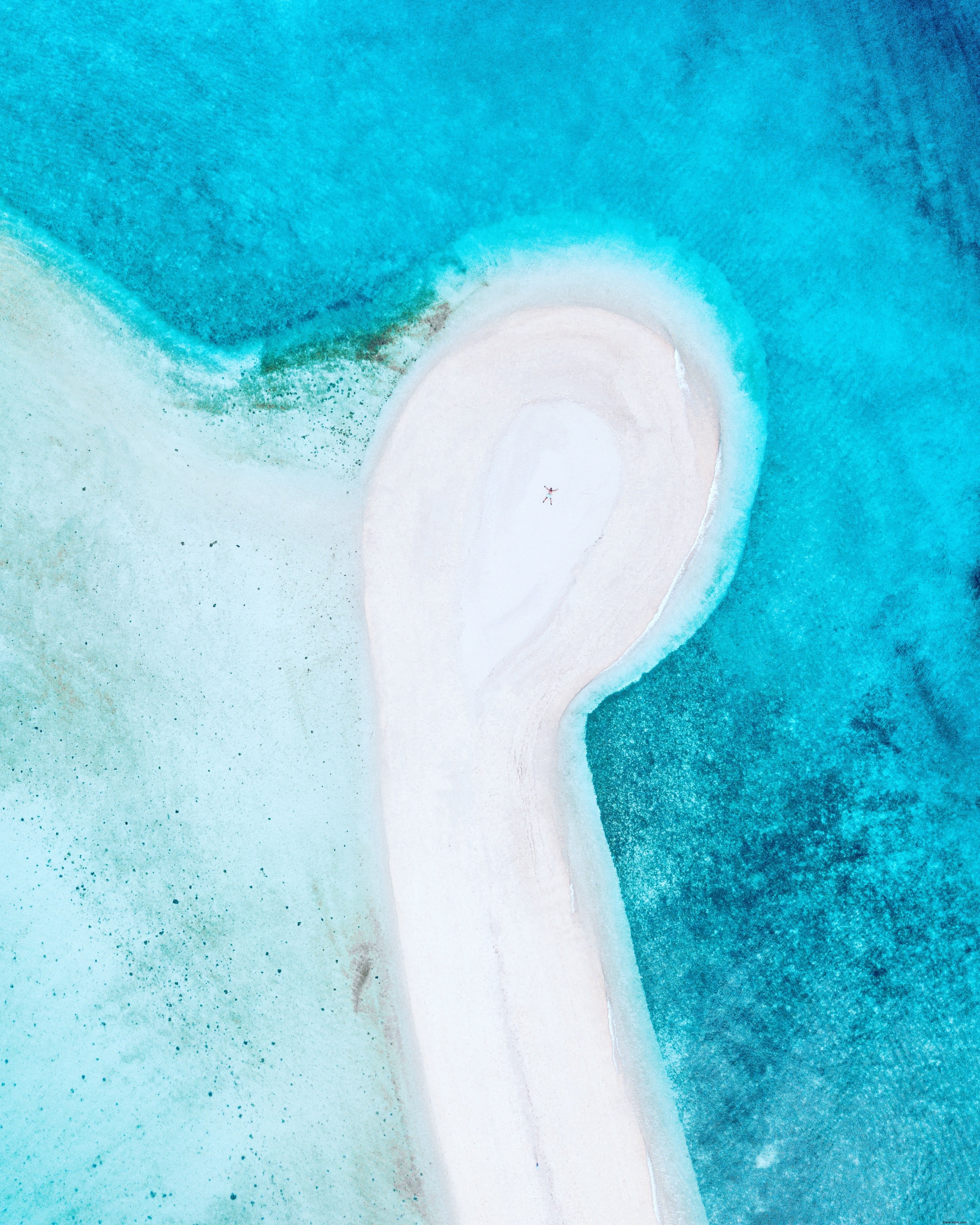 Photo aérienne d une personne sur une plage de sable blanc
