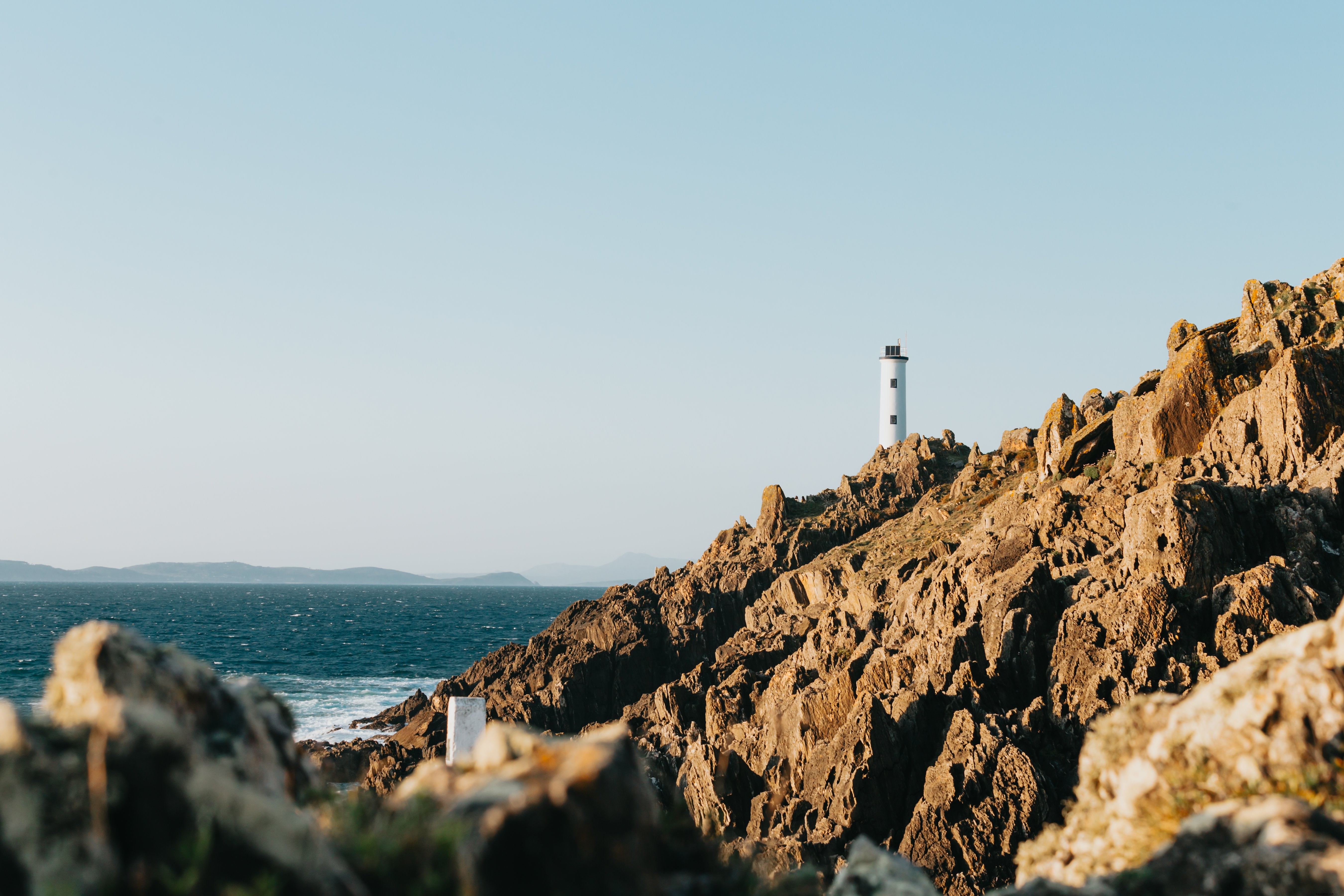 Grand phare sur Sharp Rocky Shore face à Blue Water Photo