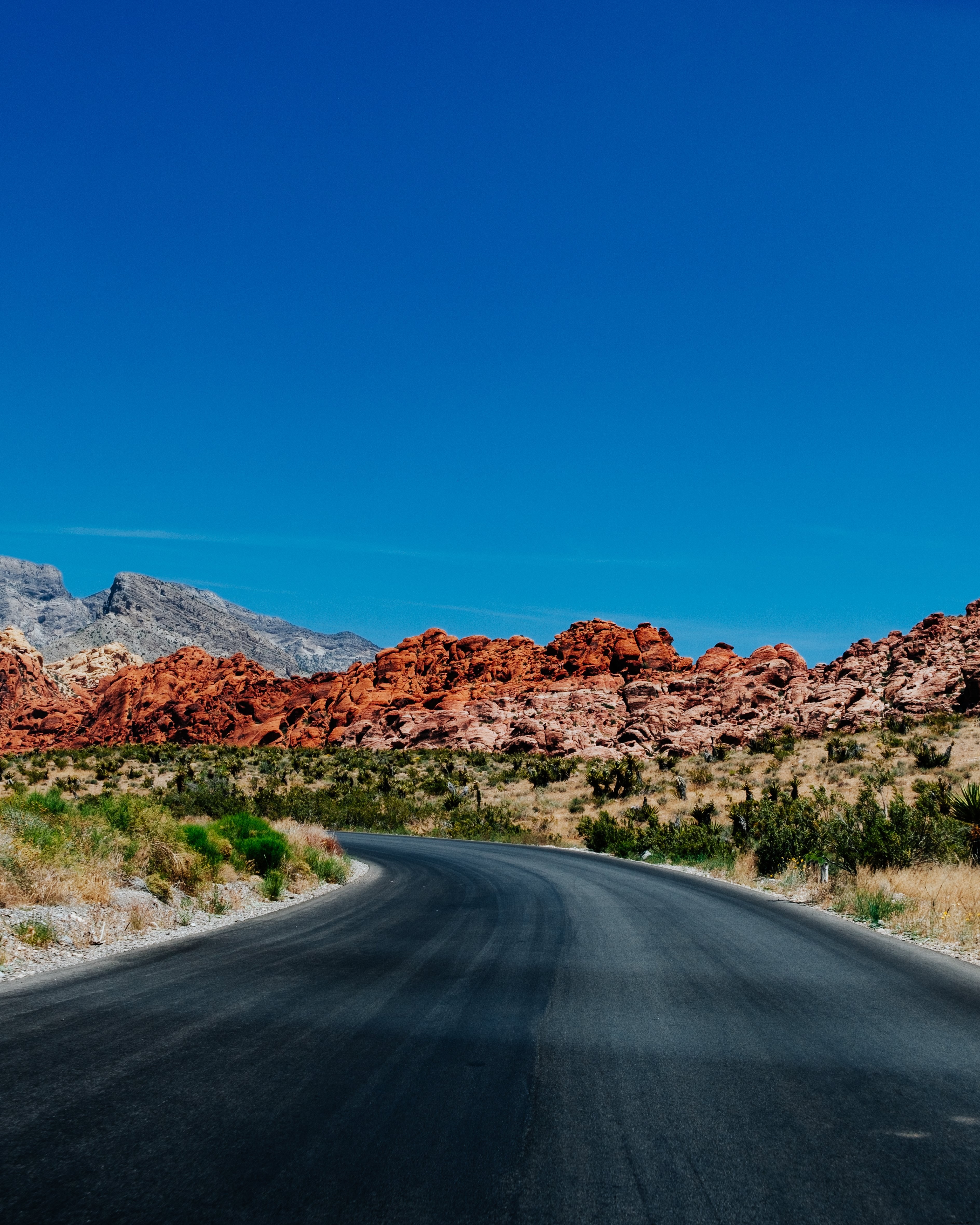 Photo d une route pavée sinueuse avec les Red Rocky Hills en arrière-plan