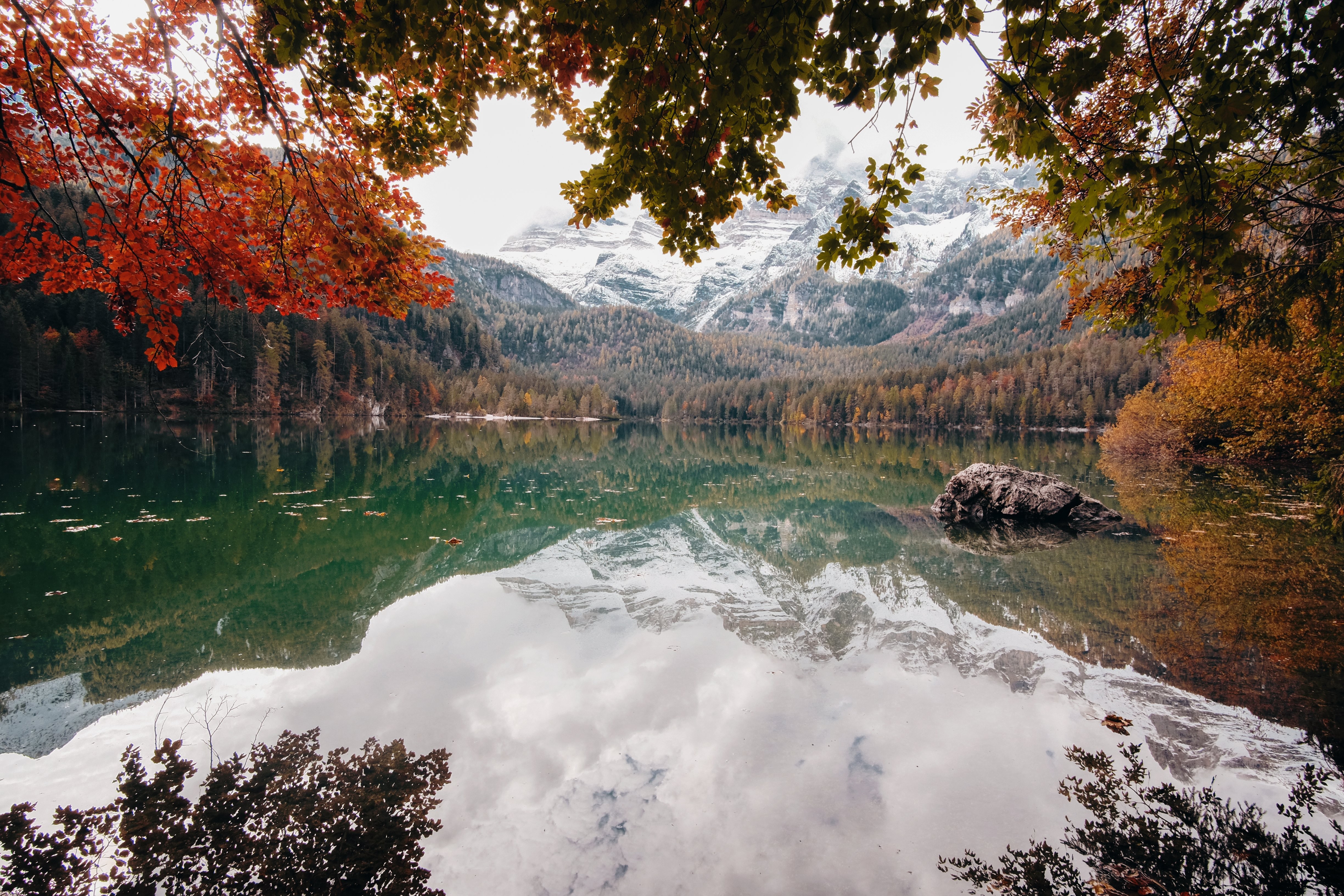 Photo d un lac en automne entouré de montagnes aux sommets enneigés