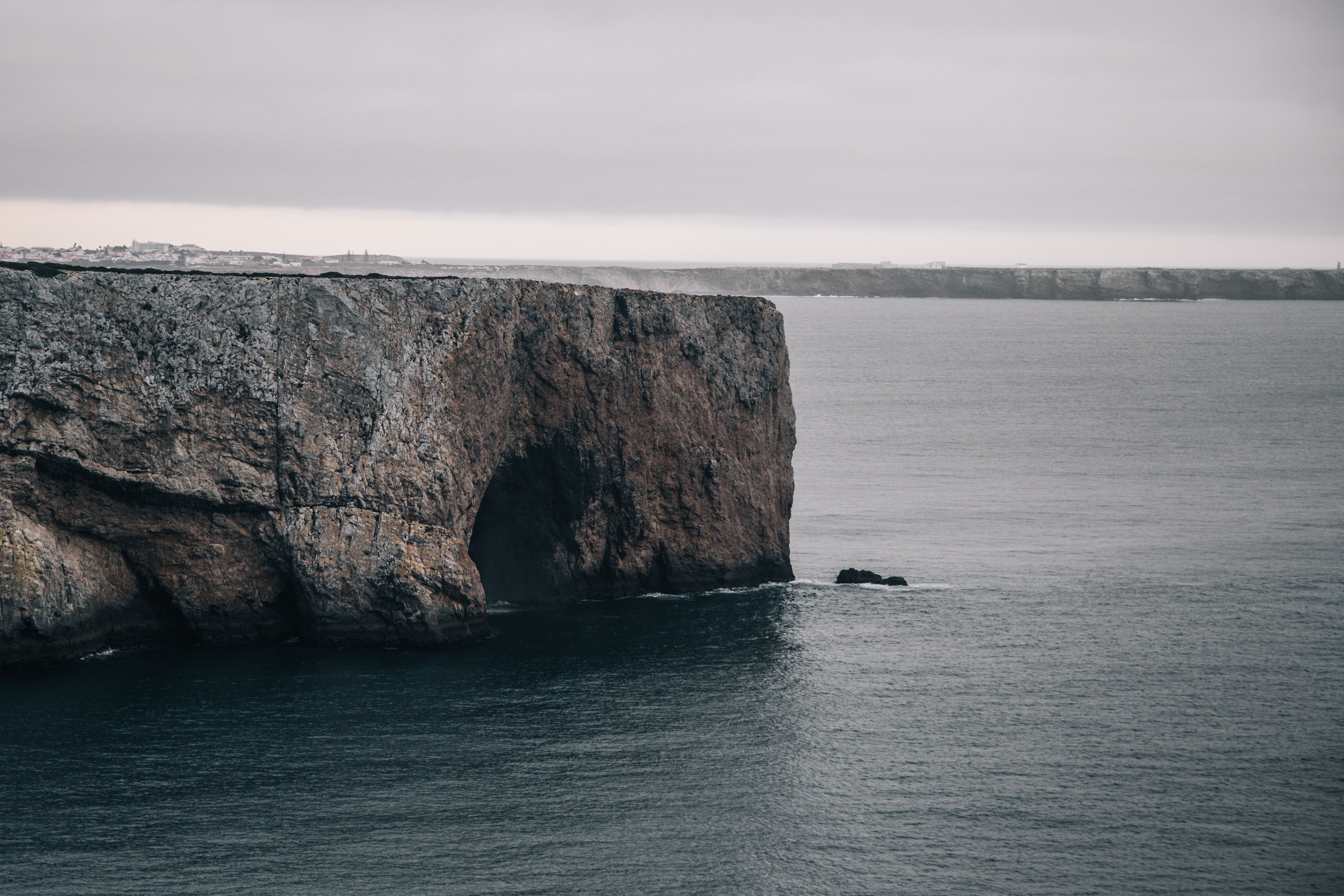 Une grotte engloutit de l eau glacée le long d une falaise