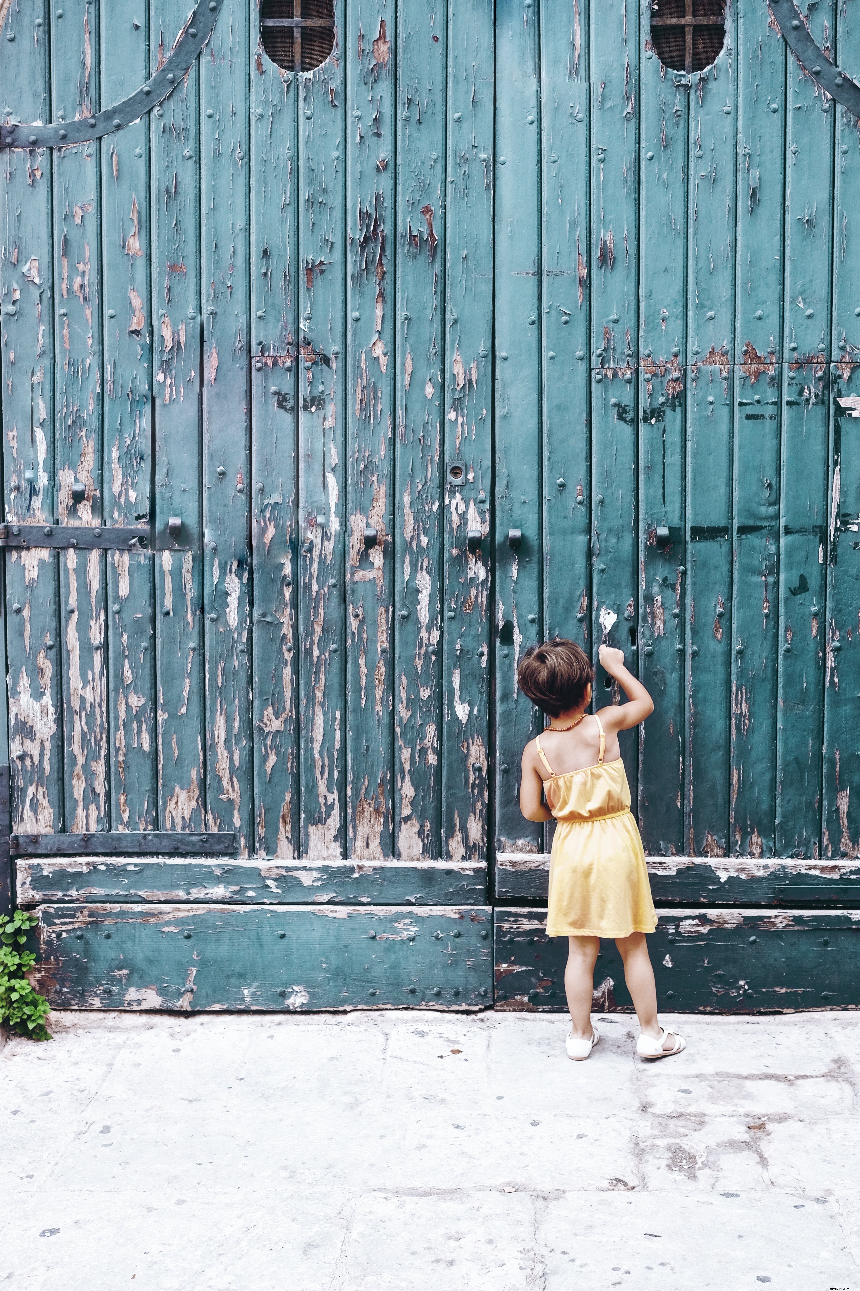 Un jeune frappe une grande photo d une porte bleue