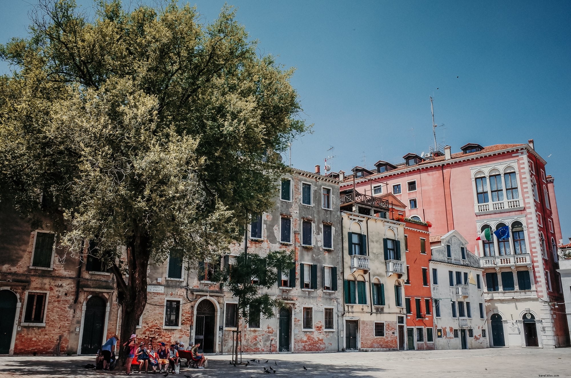 Des passants assis sur un banc à l ombre d un arbre – photo de rue