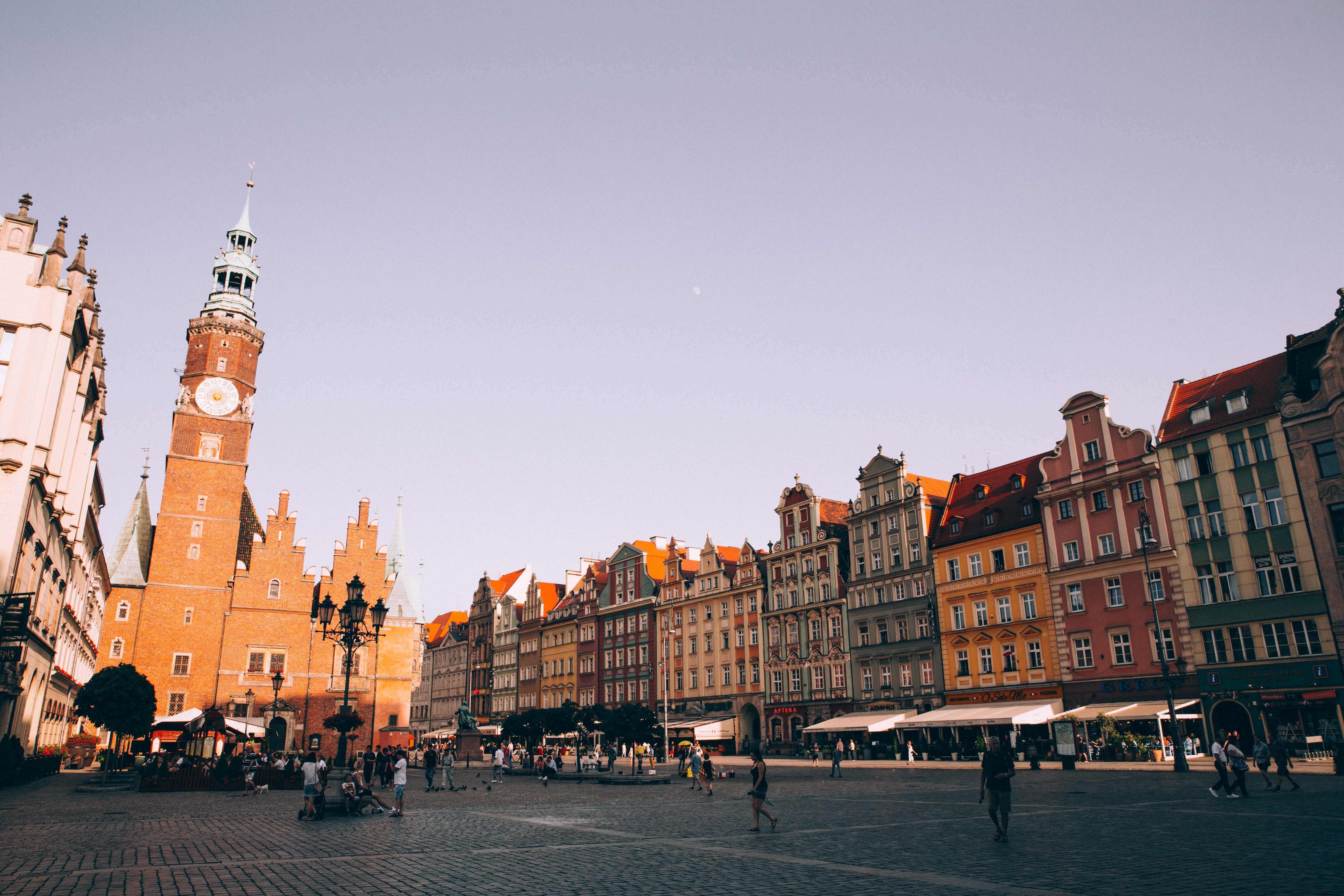 Photo d’un coucher de soleil sur une tour de briques rouges dans une piazza pavée