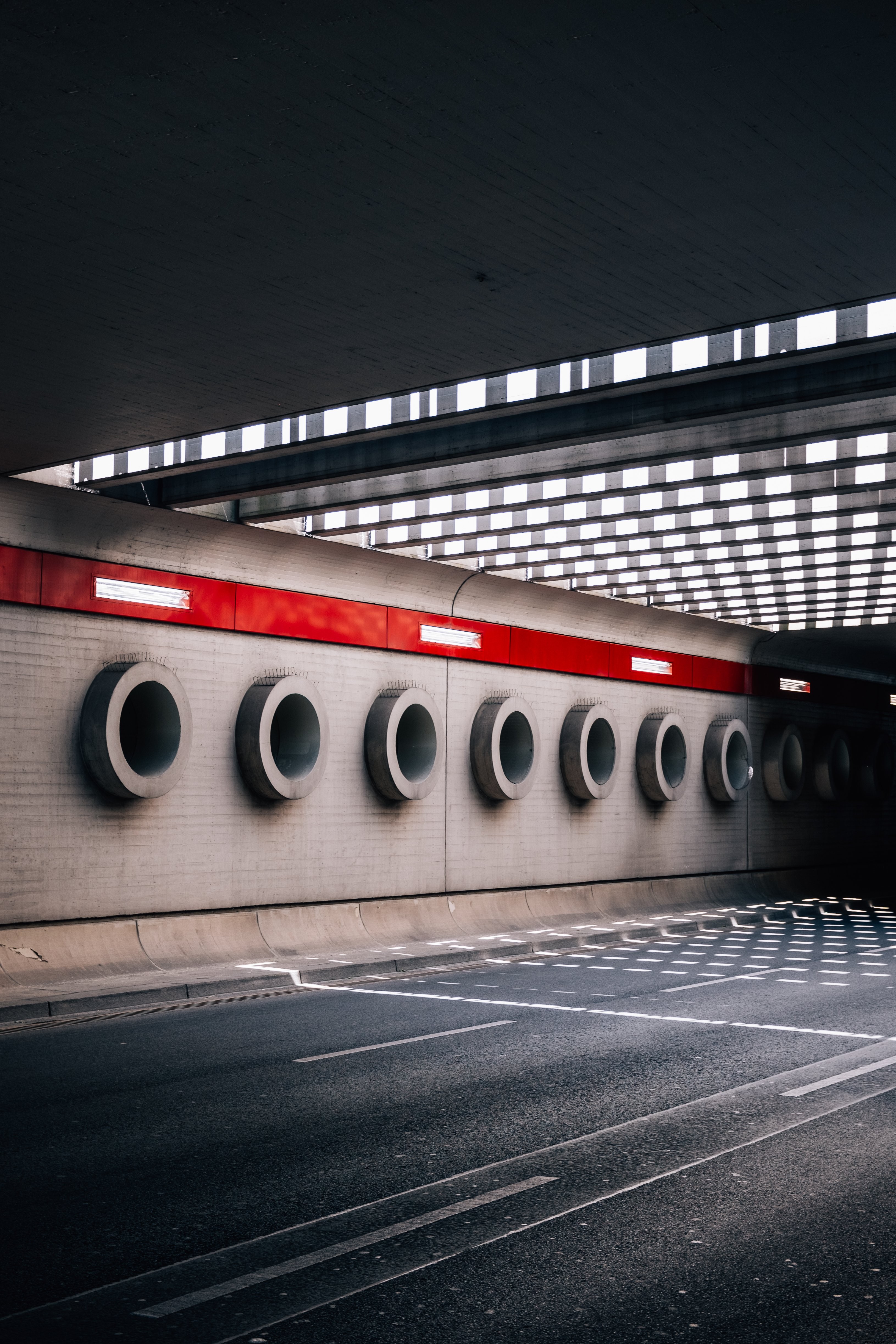 Des cercles de ciment couvrent le mur derrière une photo de viaduc