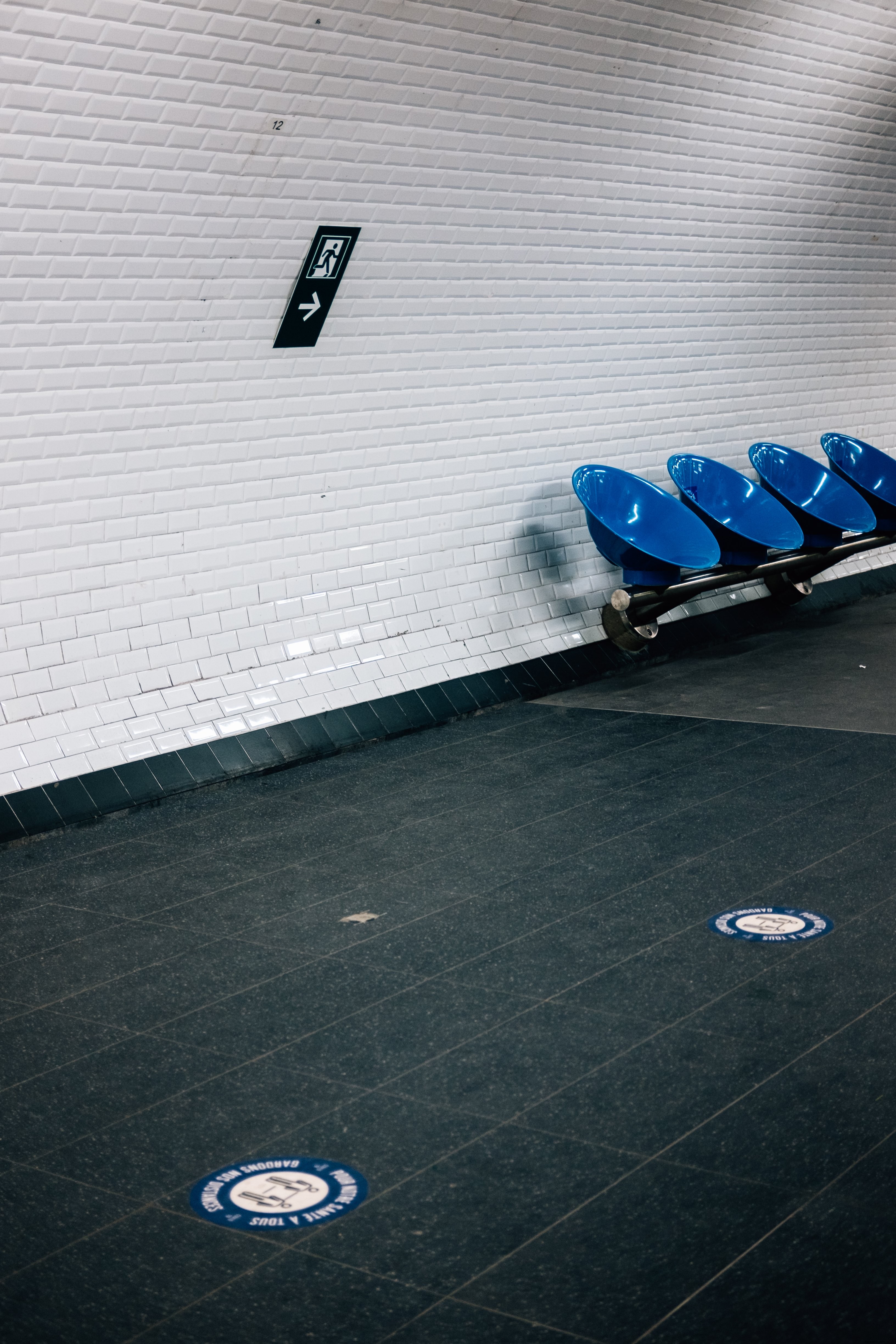 Photo d’un mur carrelé blanc avec des chaises rondes bleues