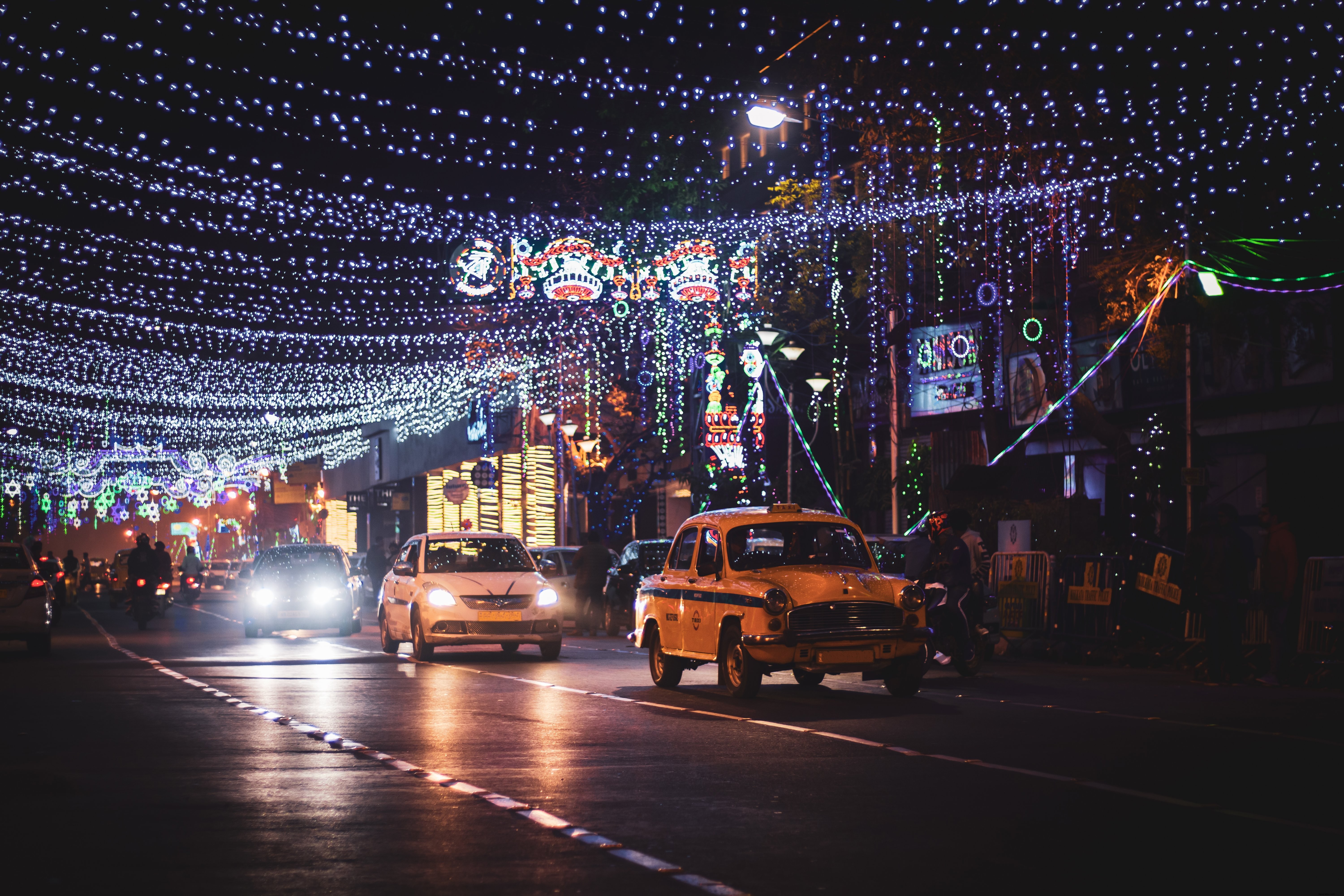 Taxi et petites voitures dans une rue illuminée