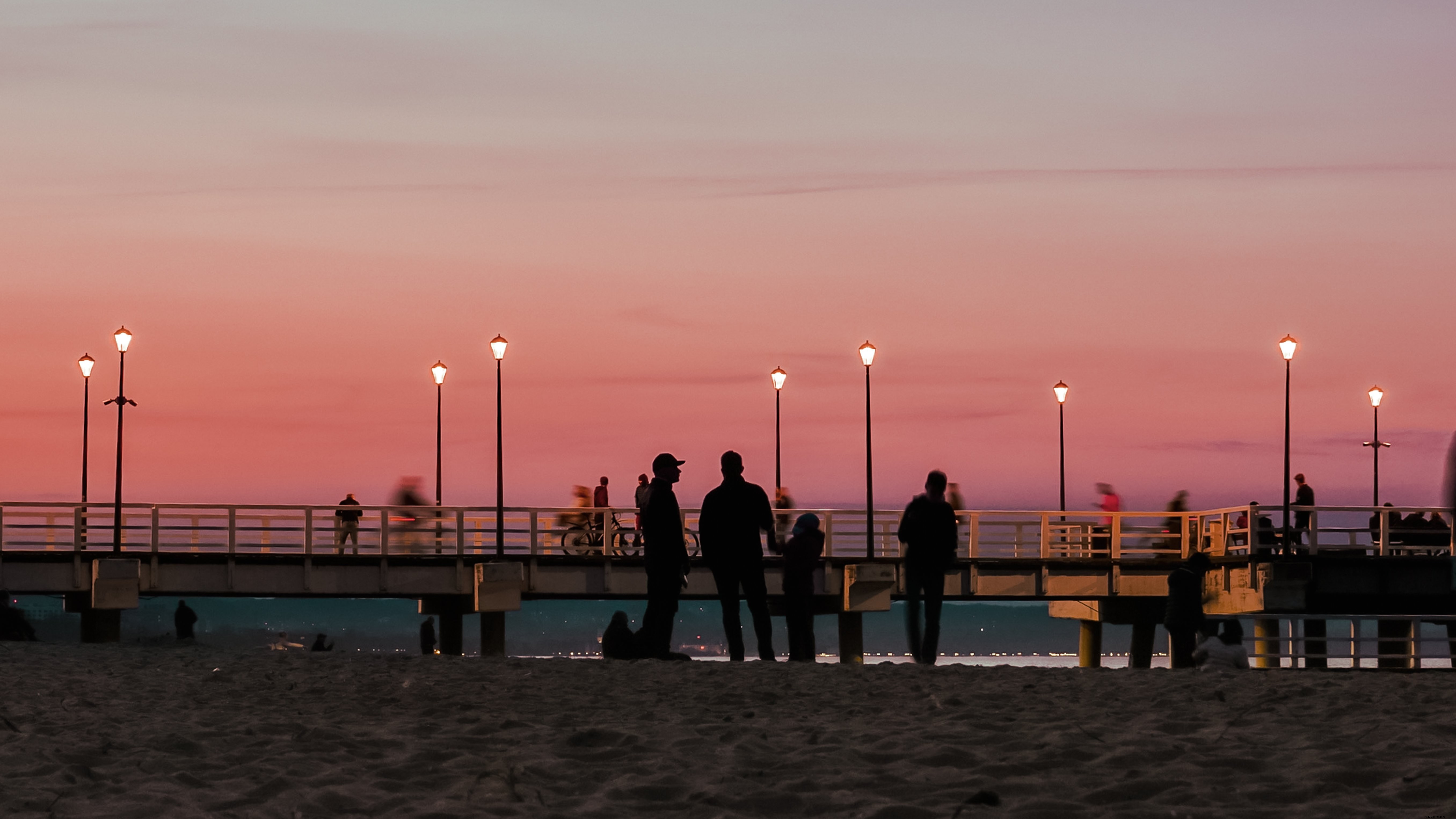 Des personnes sur la jetée au coucher du soleil